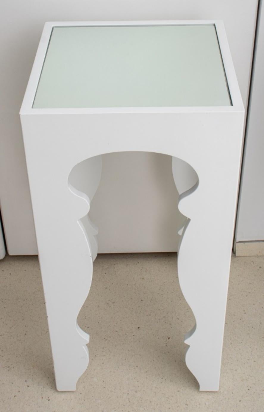 Modern white lacquered side or accent table with four scalloped legs and mirrored top. In good condition. Wear consistent with age and use.

Dimensions: 30.25