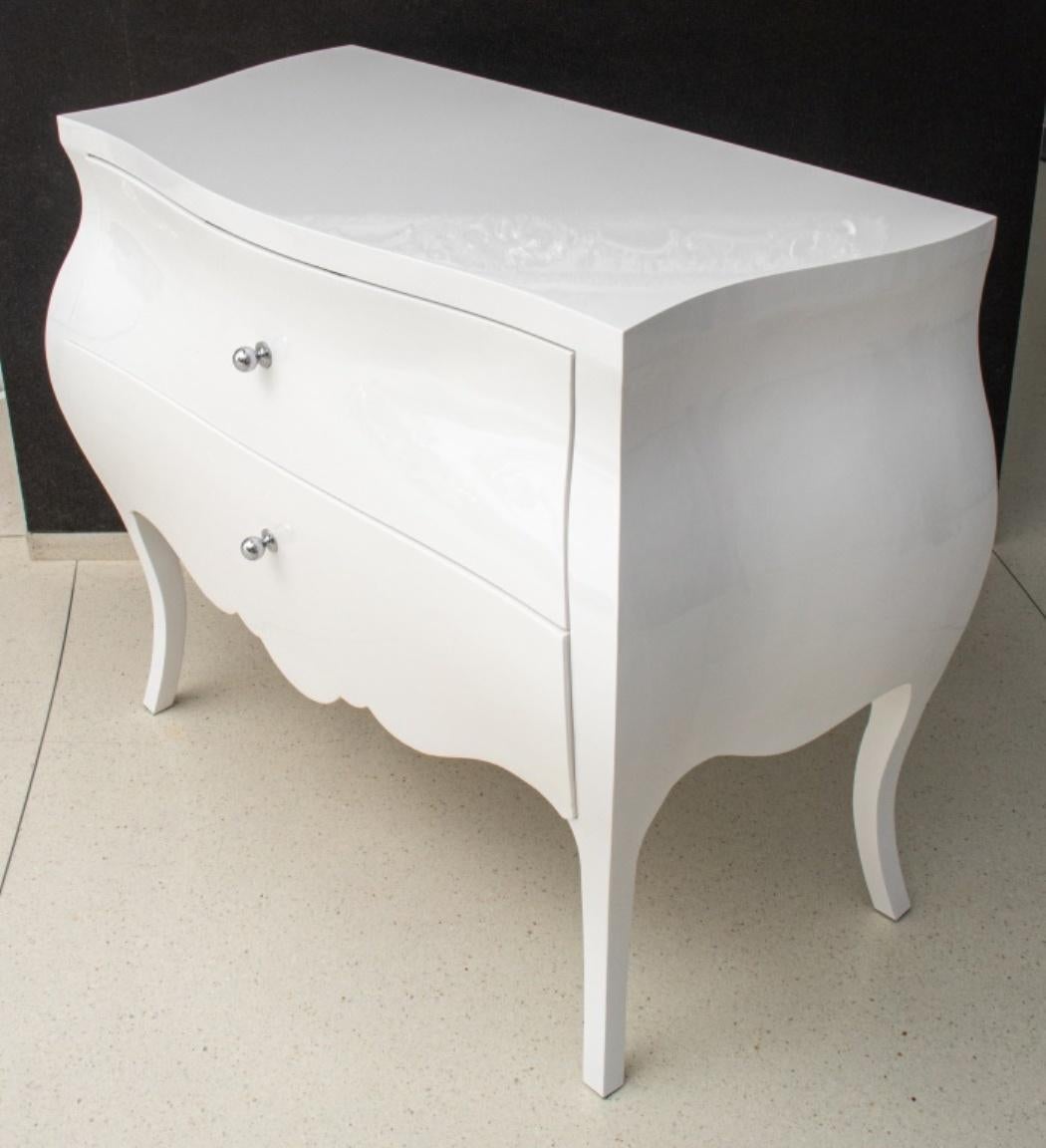 Modern white lacquered bombe chest with two drawers, skirted apron, and silver-tone metal pulls, all upon four flaring legs. In good condition. Wear consistent with age and use.

Dealer: S138XX.
