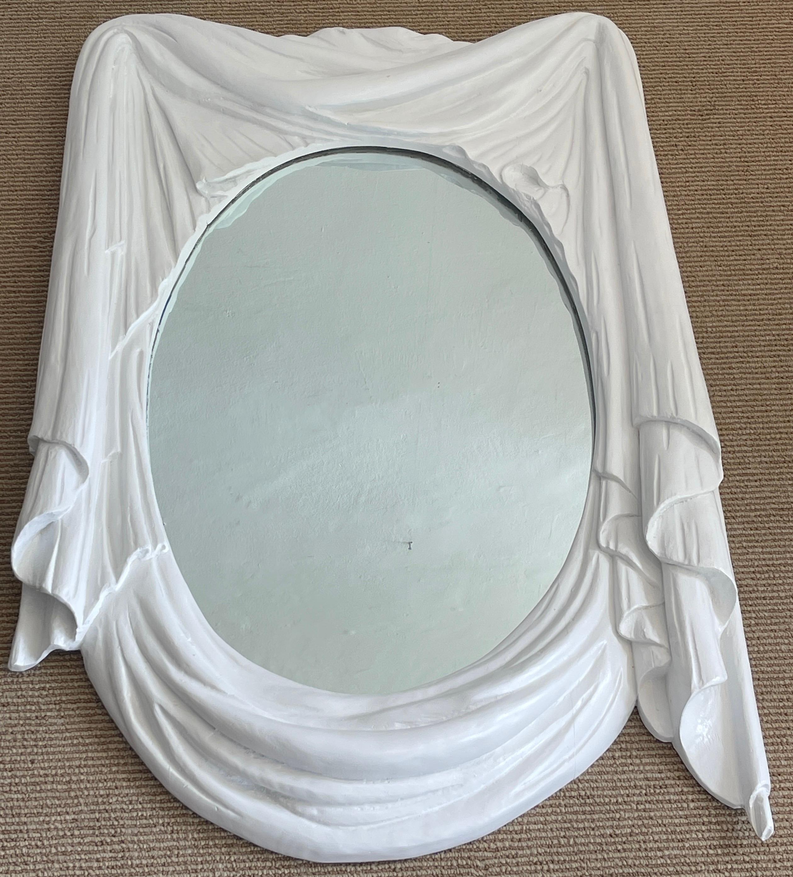 Modern white lacquered carved wood draped mirror, beautifully executed, realistically carved and lacquered in white. The inset mirror measures 19