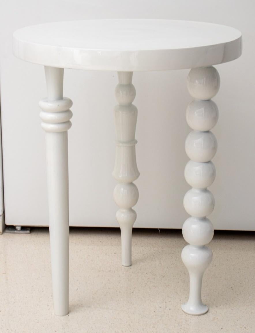 Modern white lacquered metal spindle accent or side table, the round top upon three different retro inspired legs. 24