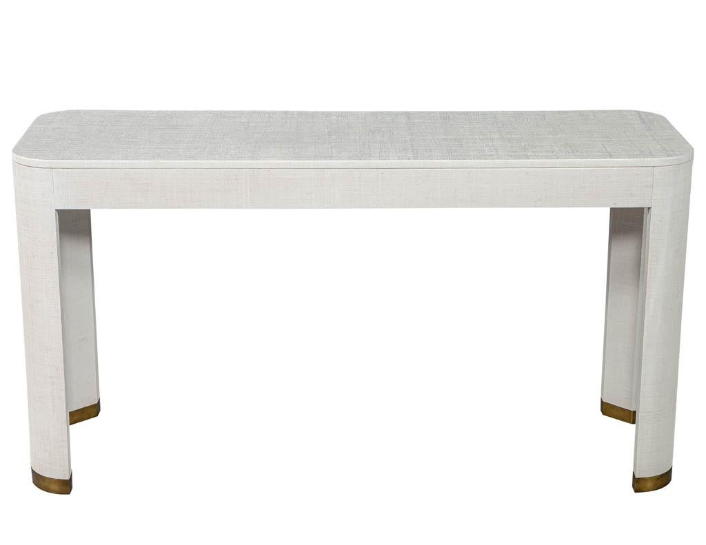 Modern white linen clad console table. Featuring clean modern design and brass capped feet.
Price includes complimentary curb side delivery to the continental USA.