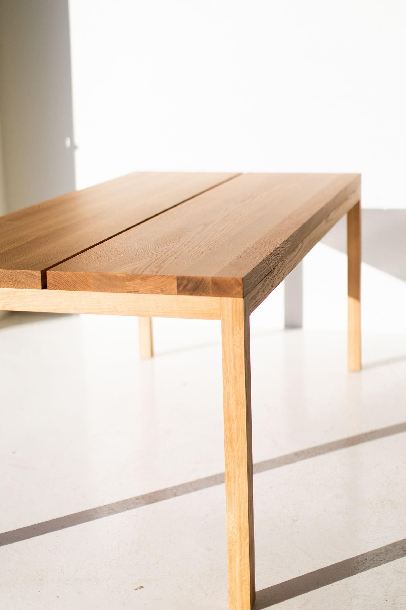 This modern white oak dining table is made in the heart of Ohio with locally sourced wood. We use this beautiful split panel table both as a modern dining table or desk. Each table is hand-made with solid white oak and finished with a beautiful