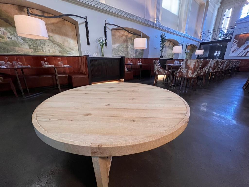 Der große runde Mitteltisch Alastair ist aus 100 Jahre alter massiver amerikanischer Weißeiche handgefertigt. Aus wiederverwendetem Eichenholz gefertigt, hat jedes Stück, obwohl es unverwechselbare Markierungen trägt, einen zeitlosen Altholzstil.