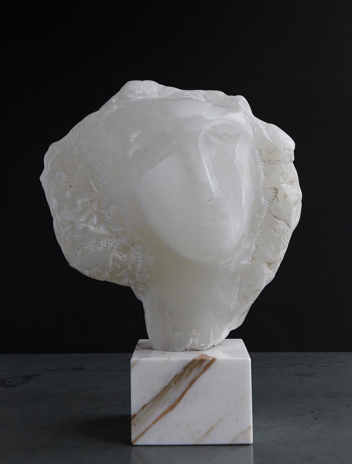 Beautiful modern white onyx sculpture of a woman's face mounted on a square marble base.
Depending of the placement of the piece, the sculpture seems to glow when it is backlit through a window light, please see photos.
Measurements: Sculpture: H
