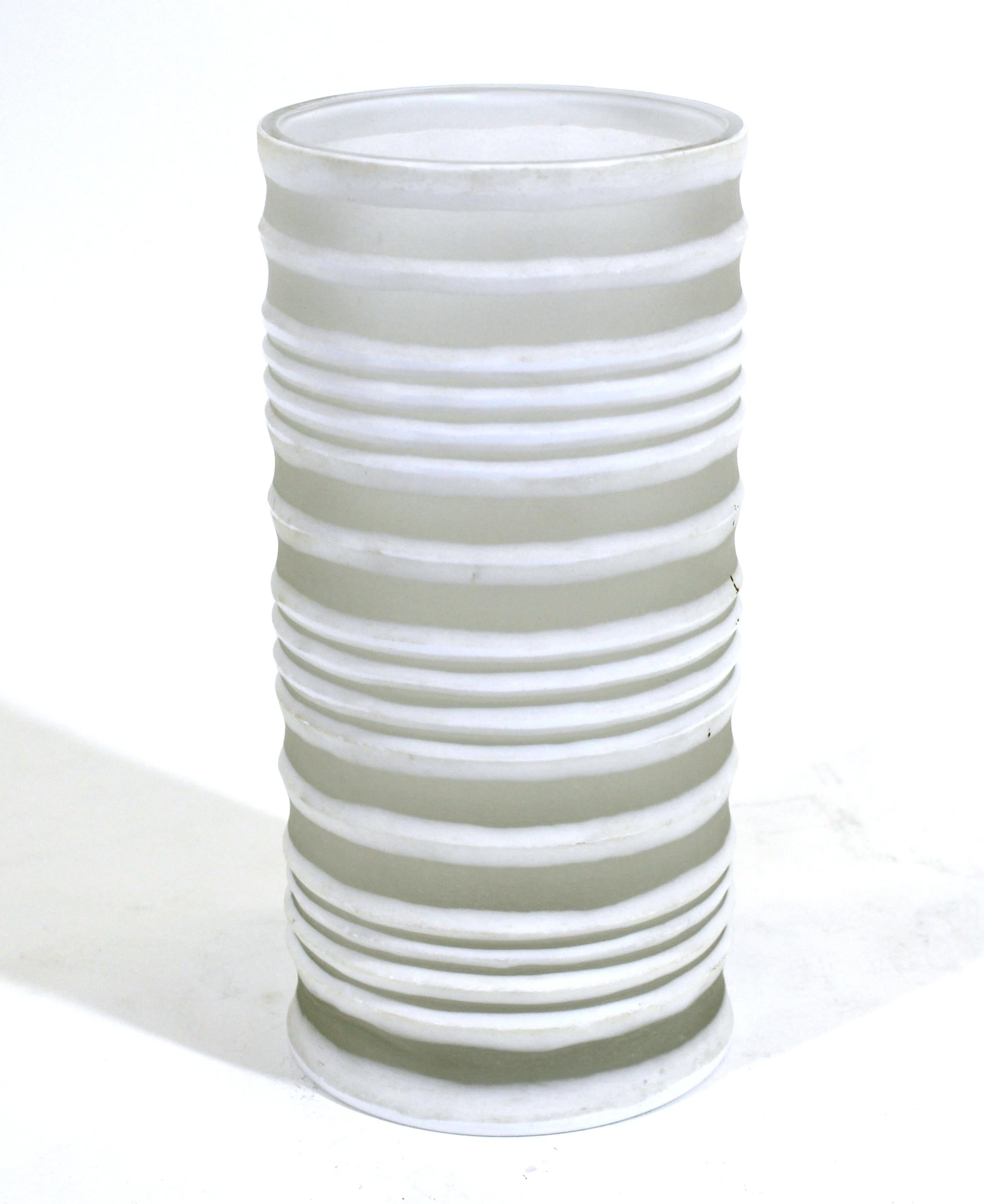Modern white glass vase in tubular shape with ribbed bands effect.