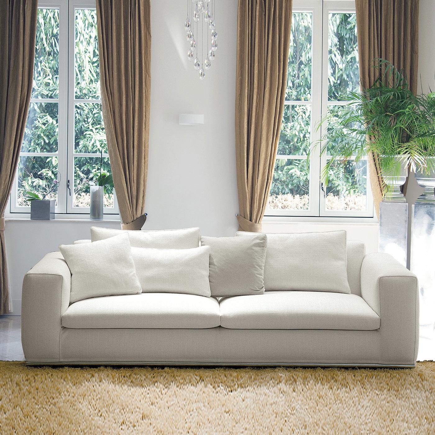 This sophisticated sofa manages to channel pure fluffiness only by looking at it. Its solid beech structure raised on a glistening stainless steel base is entirely and generously padded with polyurethane foam, conveniently paired to springs for an
