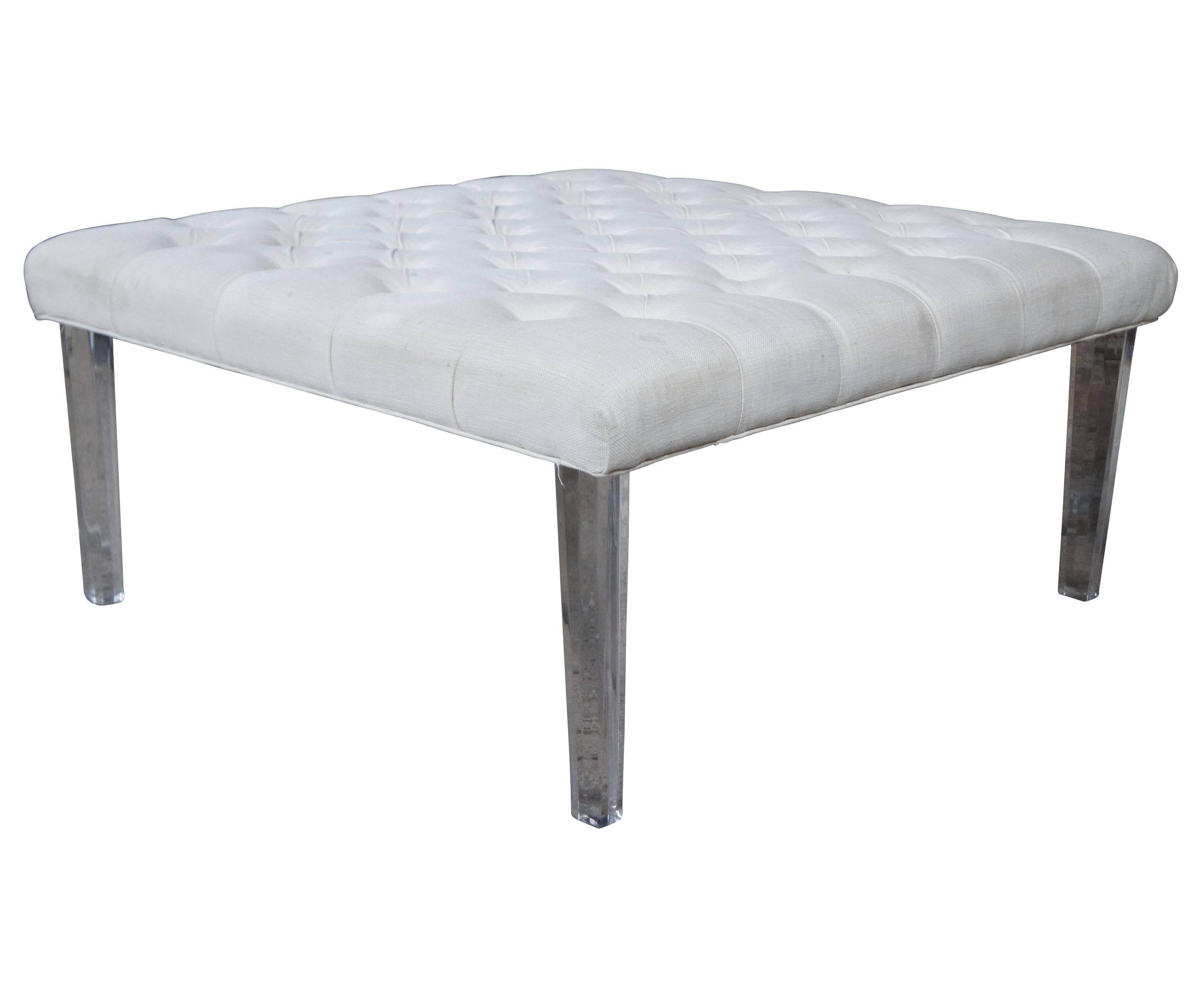 Modern upholstered ottoman in white with tufting. Supported by acrylic contoured legs.
