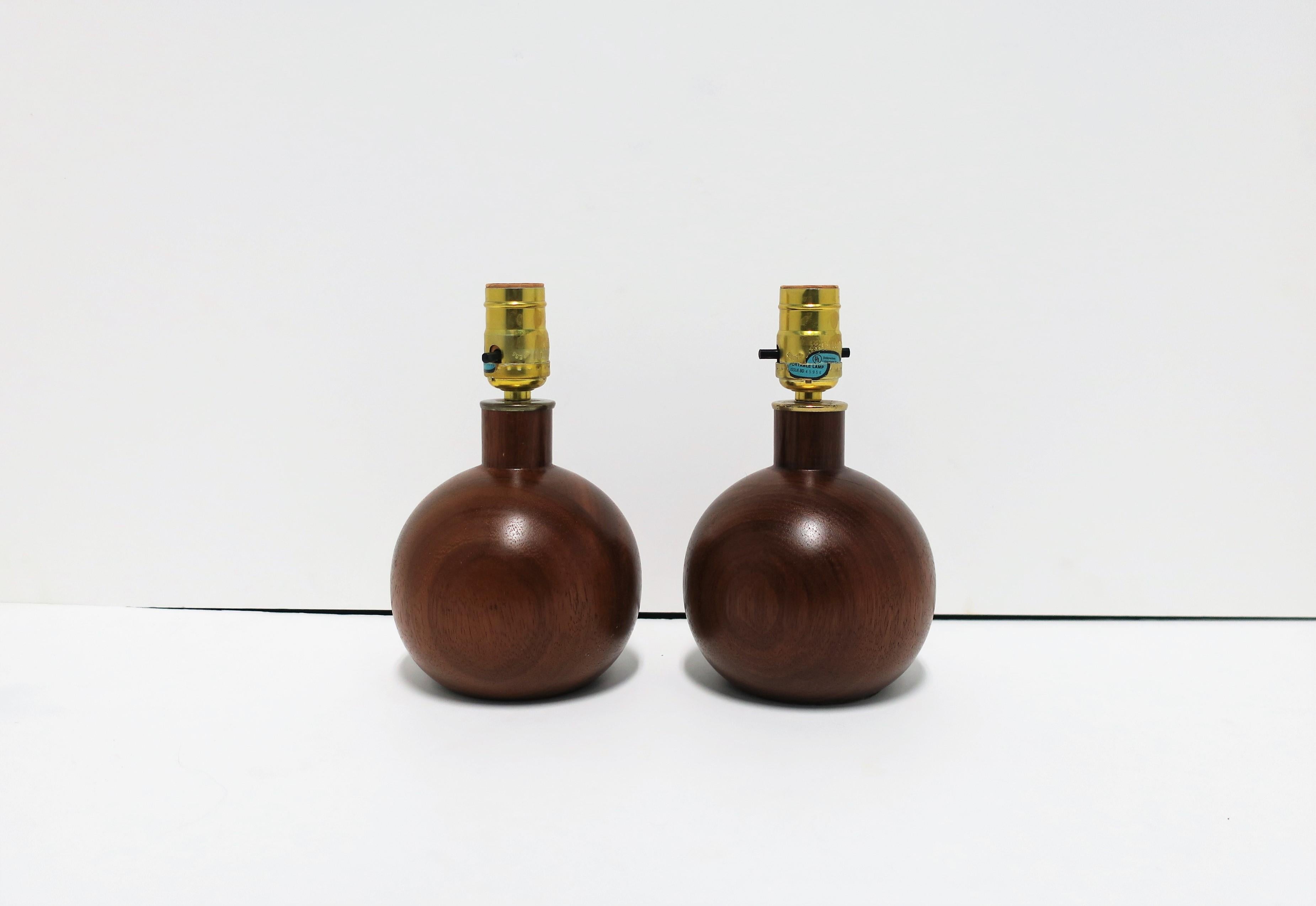 Listing/selling as a pair, but willing to split upon request. 

A small pair of modern wood and brass round ball sphere desk or table lamps, circa 1960s-1970s. Lamps may be great for nightstand tables, walk-in-closet, fireplace mantle, vanity, etc.;