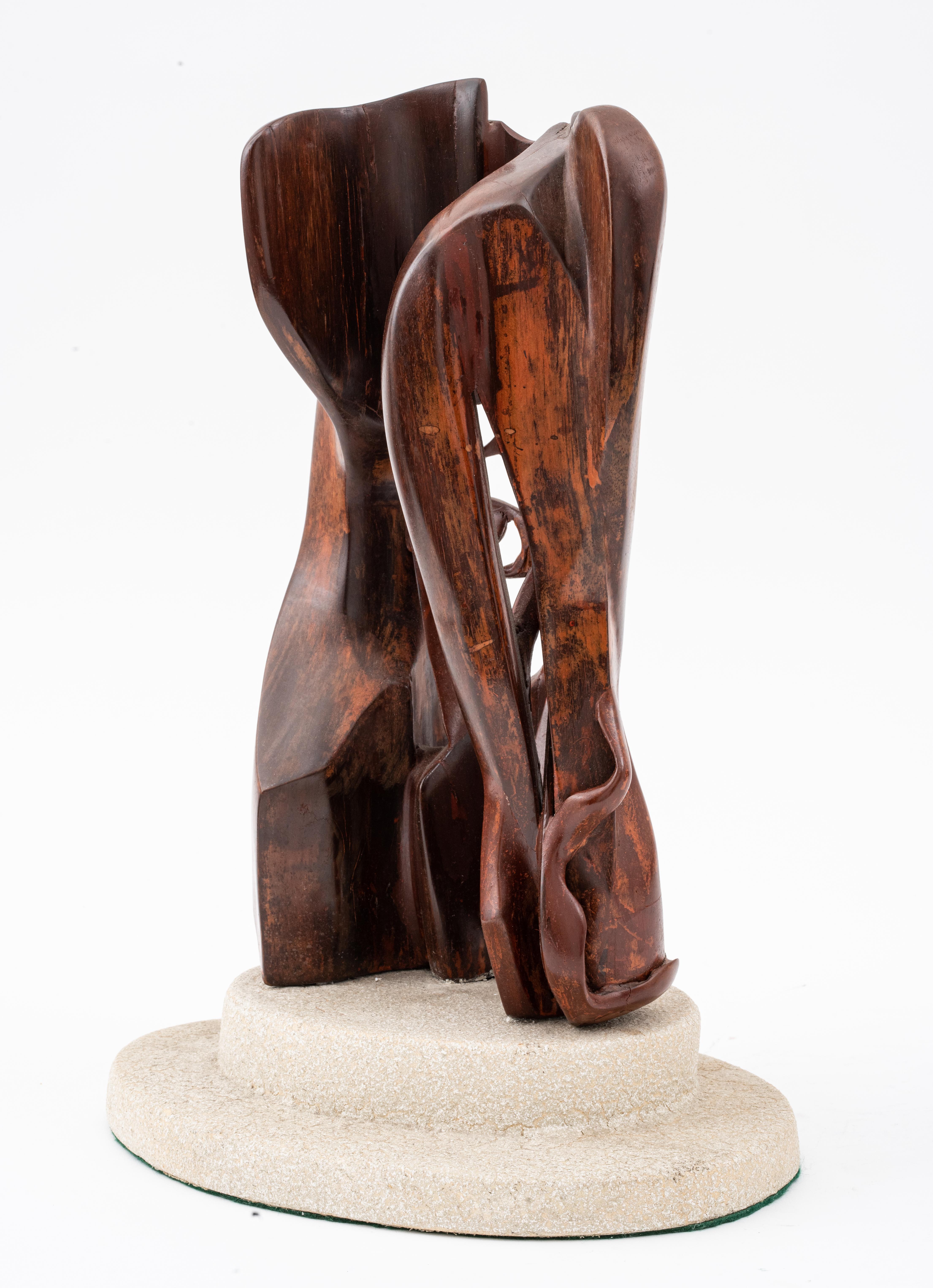 Sculpture moderne en bois représentant un visage dans des formes abstraites, sans signature visible, montée sur une base ovale en pierre. Avec la base : 17,25