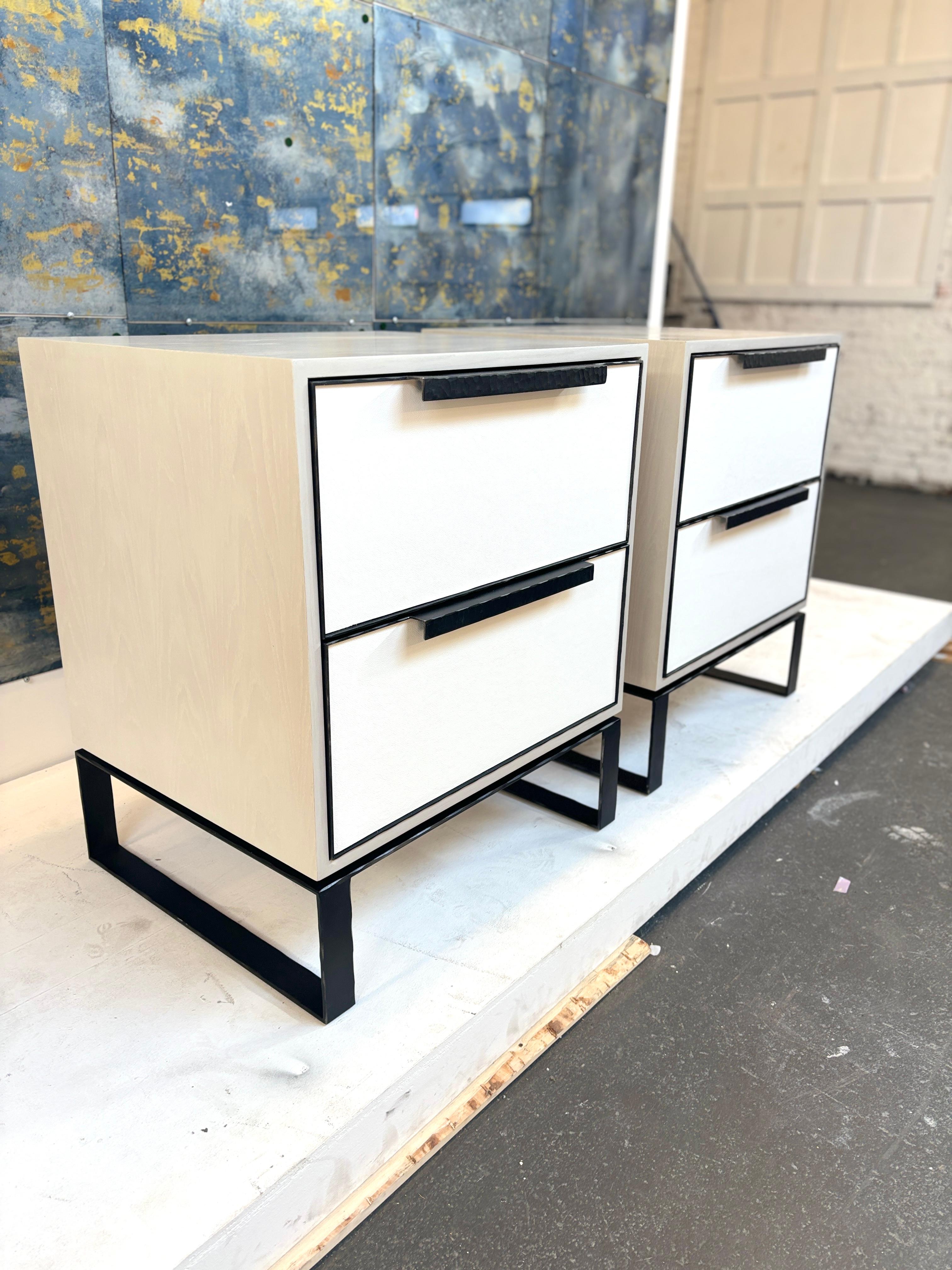 The Modern Chelsea 2-drawer leather nightstand is made up of two leather drawers covered in white leather. The Nightstand is coated in a washed Ivory Oak wood finish which pairs perfectly with the natural steel hand hammered frame and handle.