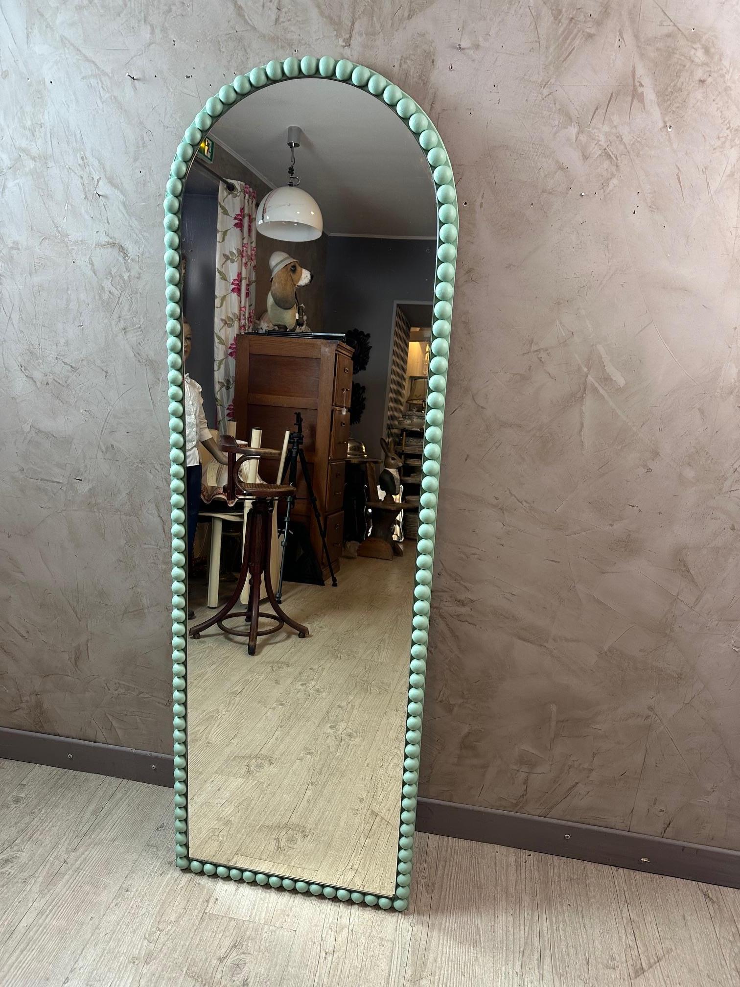 Un grazioso specchio ovale da appoggiare sul pavimento. Realizzato a mano con un vecchio specchio. Decorate con semisfere in legno. Dipinto in verde chiaro. 
Lo specchio presenta alcune tracce di mercurio.
Ideale in una camera da letto o in un