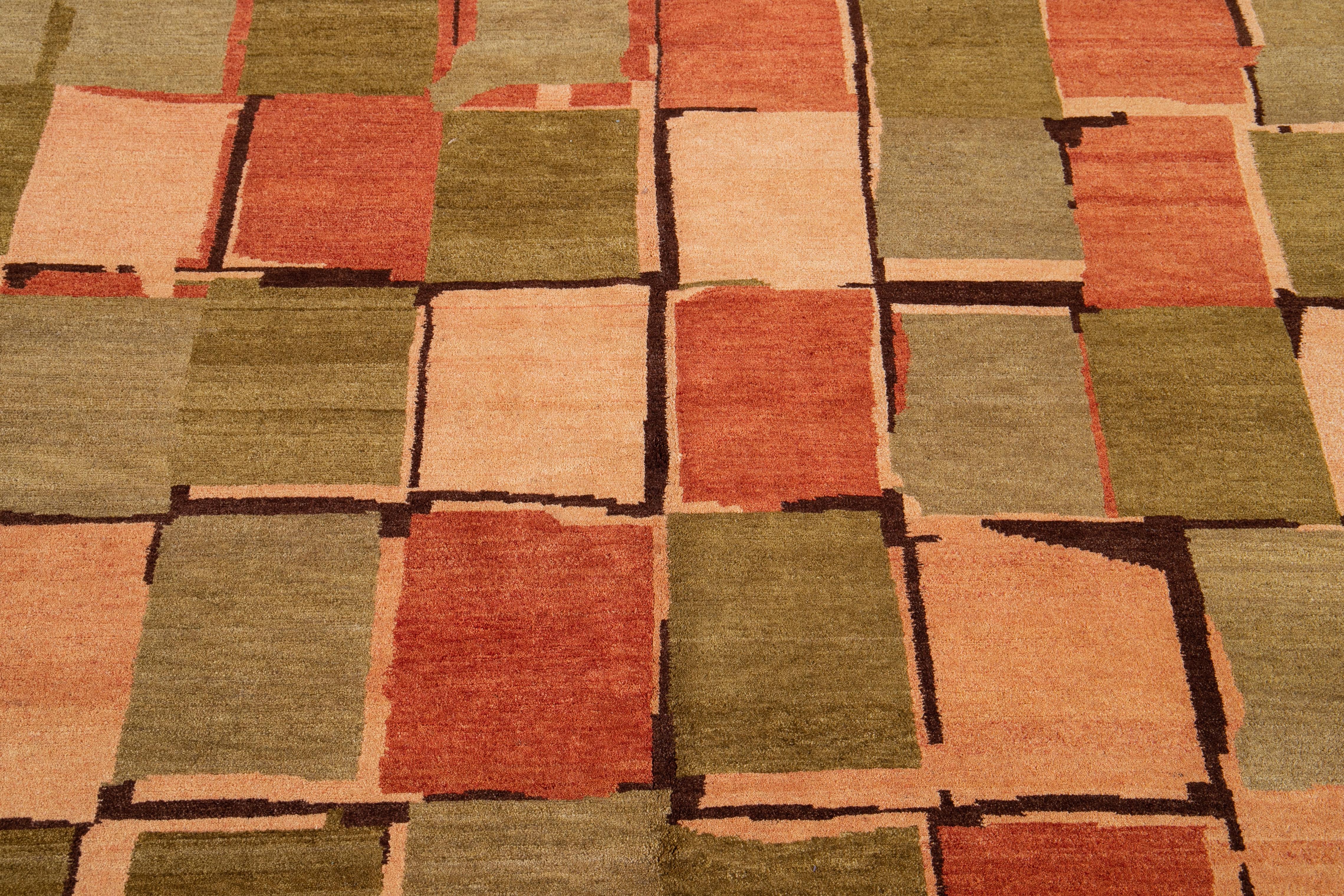 This contemporary Tibetan rug is expertly crafted by hand using wool and silk and boasts a striking green and orange color field. Adding to its charm is an all-over abstract geometric pattern in tan.

This rug measures 5'9