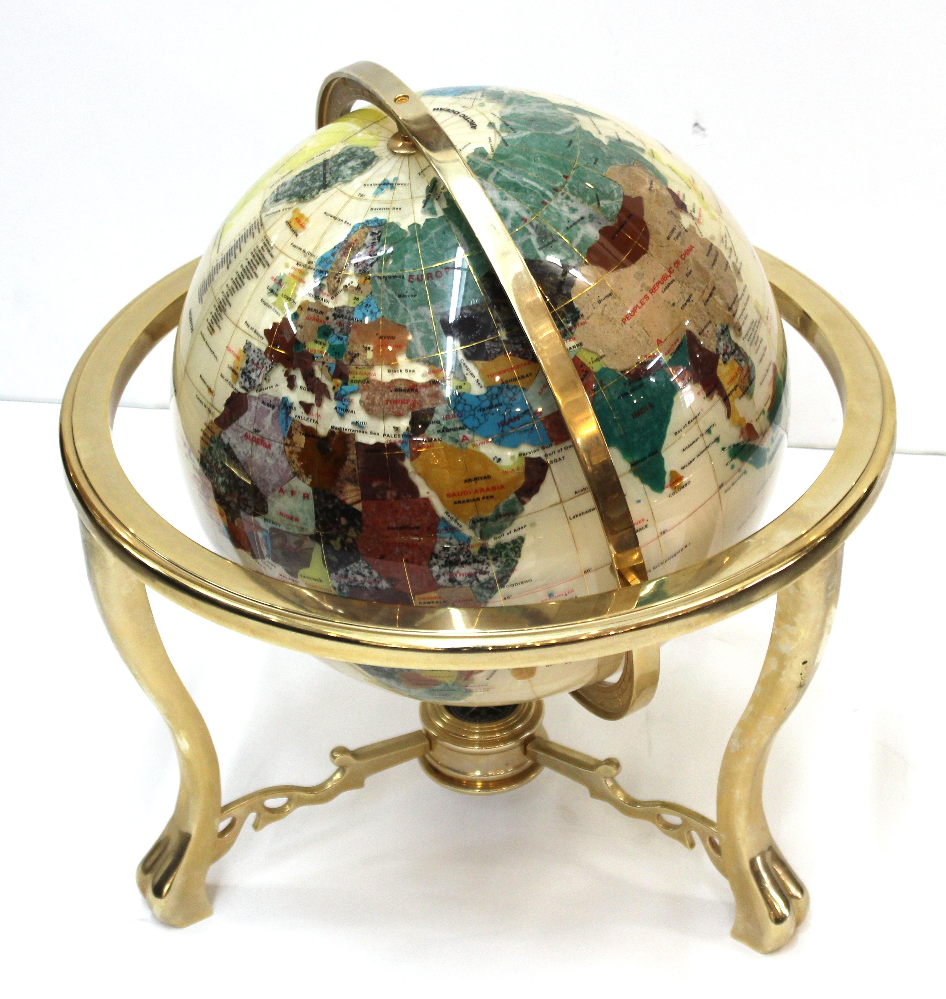 Modern world globe in semi-precious stone on heavy brass stand. The globe is made of lapis-lazuli, geodes and mother-of-pearl on top of brass fittings. Made during the 1980s in the United States. In great vintage condition with age-appropriate wear.
