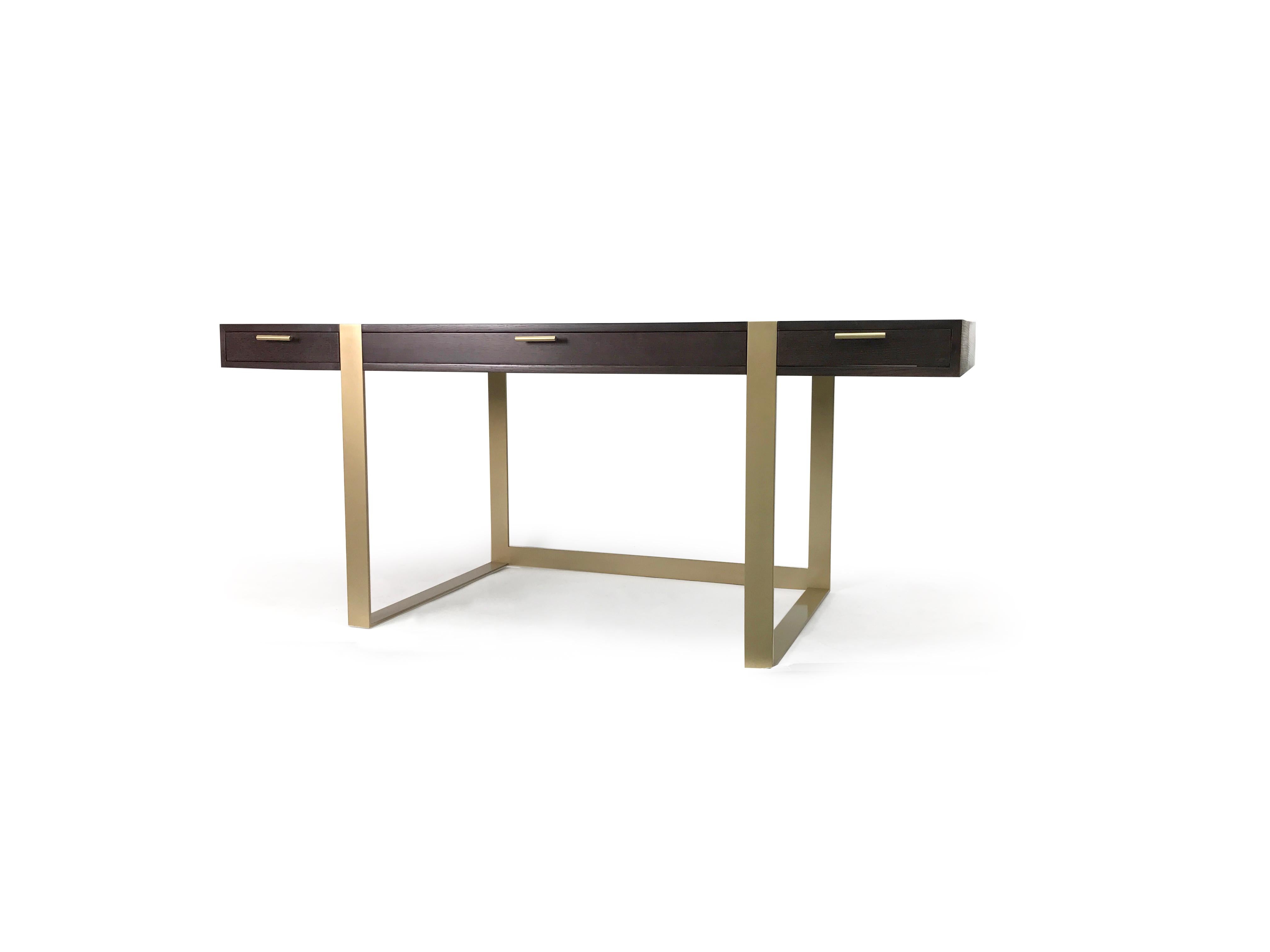 This modern writing desk was custom made for utility. The desk features 3 drawers for storage, a steel base brushed with antique brass and a white oak top stained ebony. This is a built to order piece and can be made to your specifications with your
