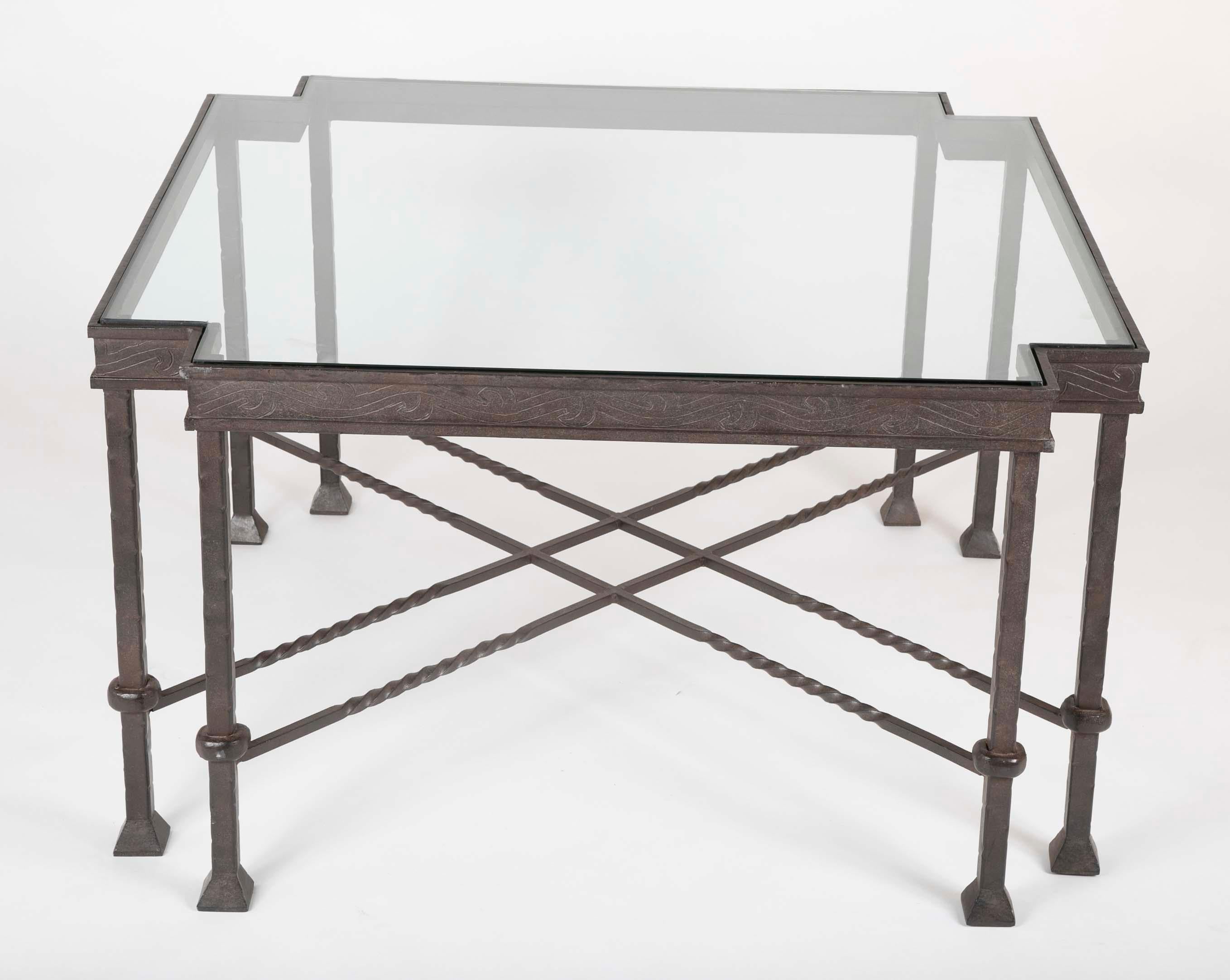 A very cool Diego Giacometti influenced wrought iron side or coffee table of unusual form, the cut corners with paired legs joined by double stretchers. The glass top framed buy a frieze with etched decoration. This geometric table, with its eight
