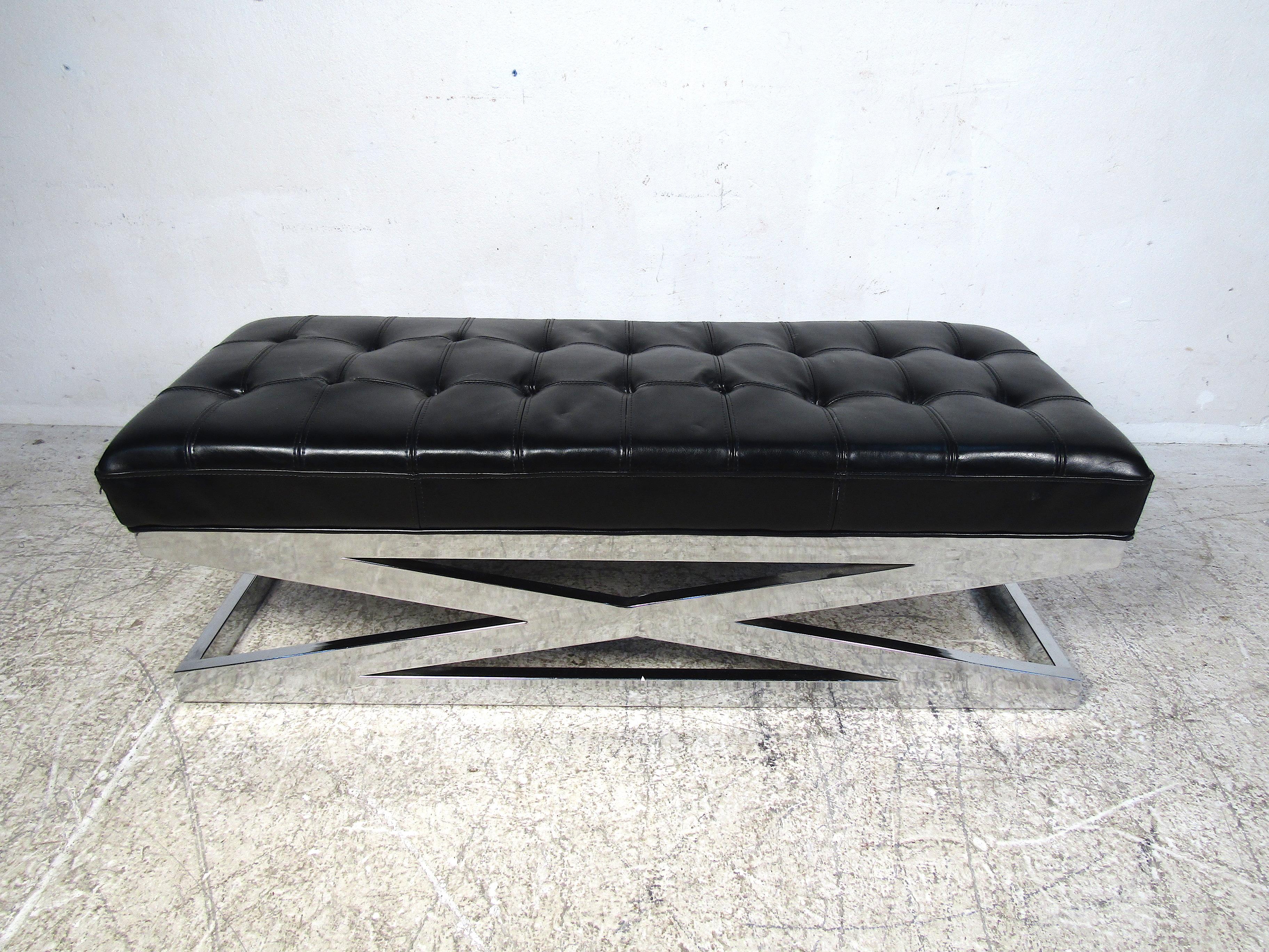 Banc rembourré moderne et élégant. Base chromée robuste en X. L'assise paddée est recouverte d'un revêtement en similicuir noir tufté. Une belle pièce qui ne manquera pas de compléter tout intérieur moderne. Veuillez confirmer la localisation de