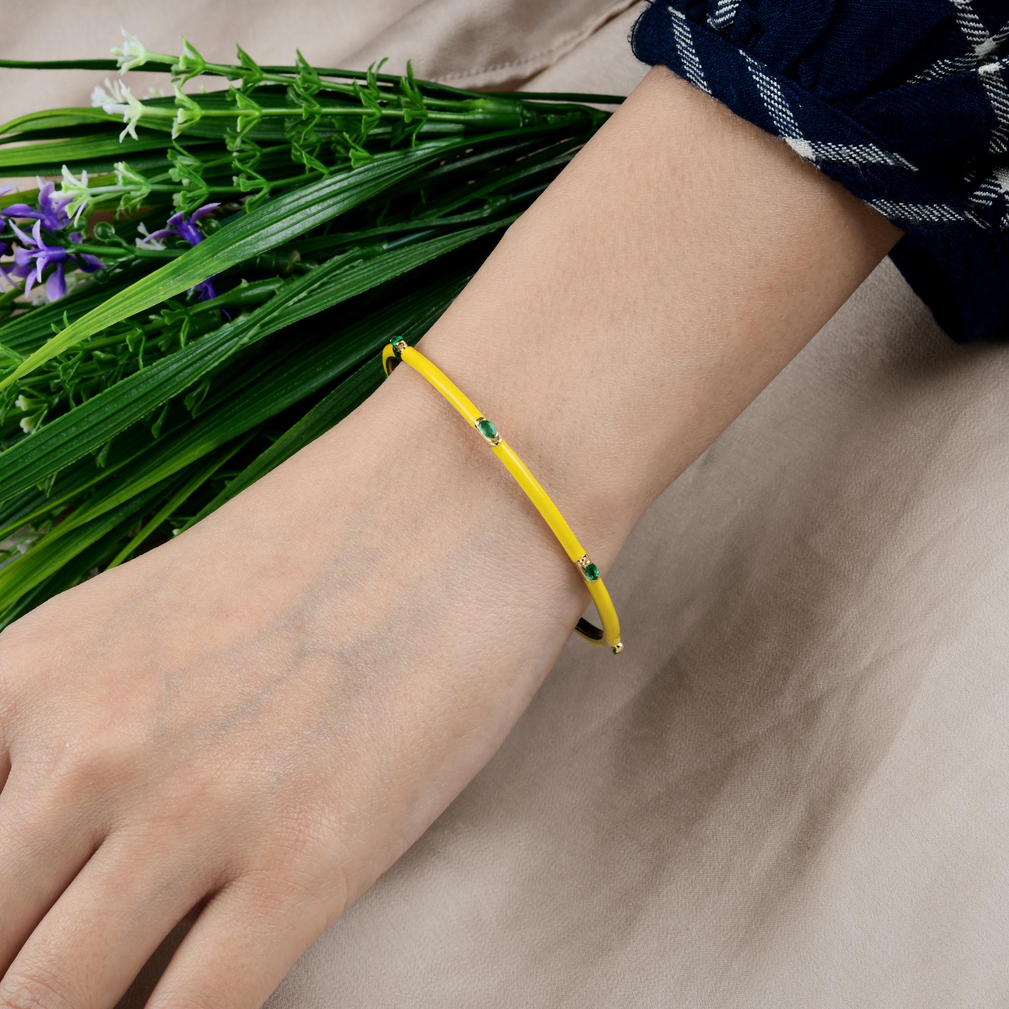 Modern Yellow Enamel Bracelet 14 Karat Yellow Gold Emerald Studded Gold Bangle
It features a smooth yellow enamel exterior, evenly spaced around the bangle are brilliant green emeralds, each delicately bezel-set. 
Emeralds are symbols of love,