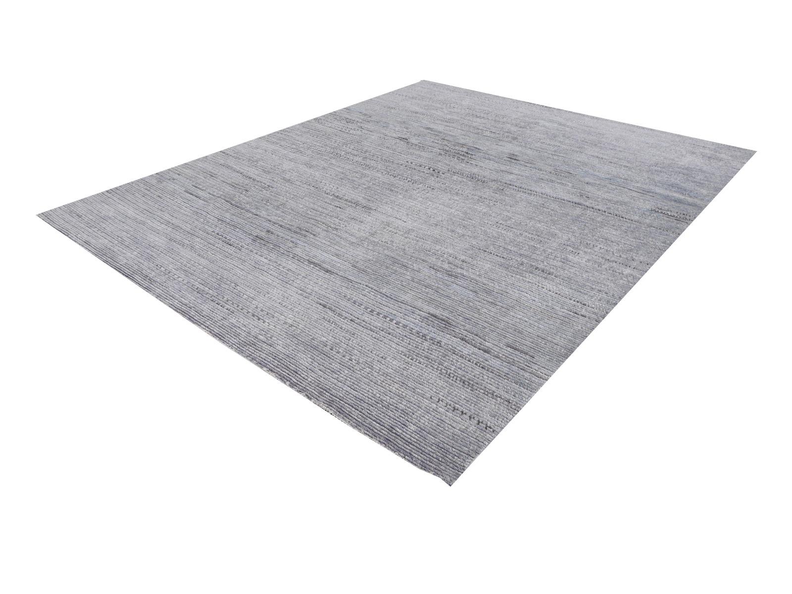 A beautiful Zagora rug 8 x 10 ft. This modern rug is hand knotted and has a wool pile in trending interior design shades. On a gray and blue field, the design in style of traditional Beni Ourain Berber rugs shows small stripe elements standing next