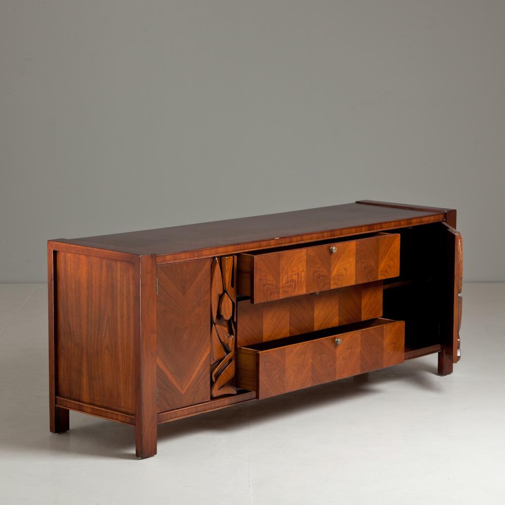 A wooden cabinet with abstract door mouldings, designed by Modernage Furniture Company, Miami, Florida, USA, 1950s

This piece is stamped to inside drawer.

Modernage Furniture Company have been in operation since 1957, manufacturing and retailing