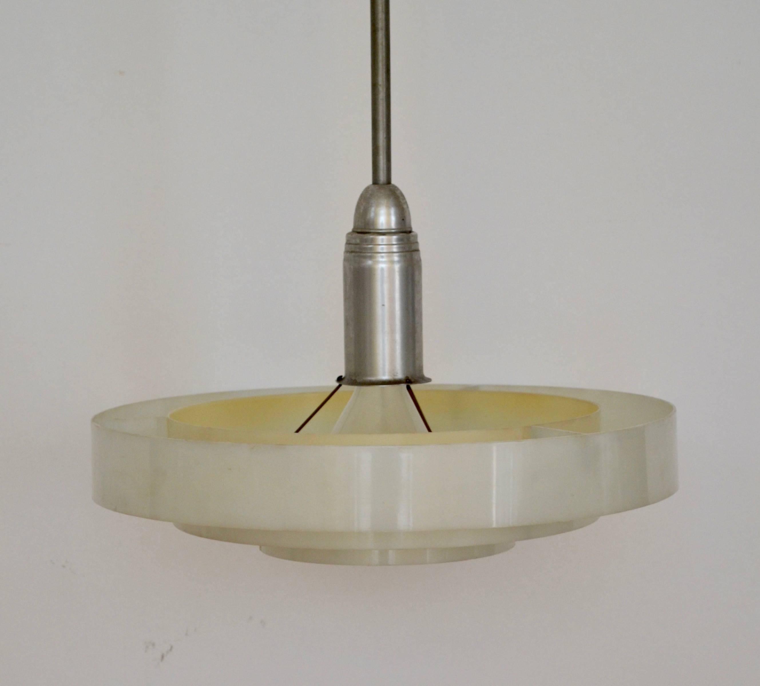 These three-ring plexiglass diffusers are suspended from spun aluminum socket housing, with stem and swivel canopy. Original mogul base porcelain socket had been fitted with a reducer to permit use of medium base (standard) bulbs. Some mellowing of