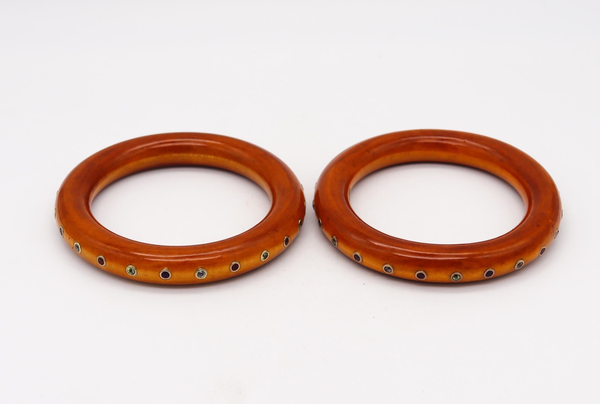 Suite of lacquered burl wood bangles.

Very handsome and elegant pair of Italian bangles carved from natural light brown burl wood with lacquer finish. Inlaid in the wood with multiples round bezels mounted with natural gemstones of different