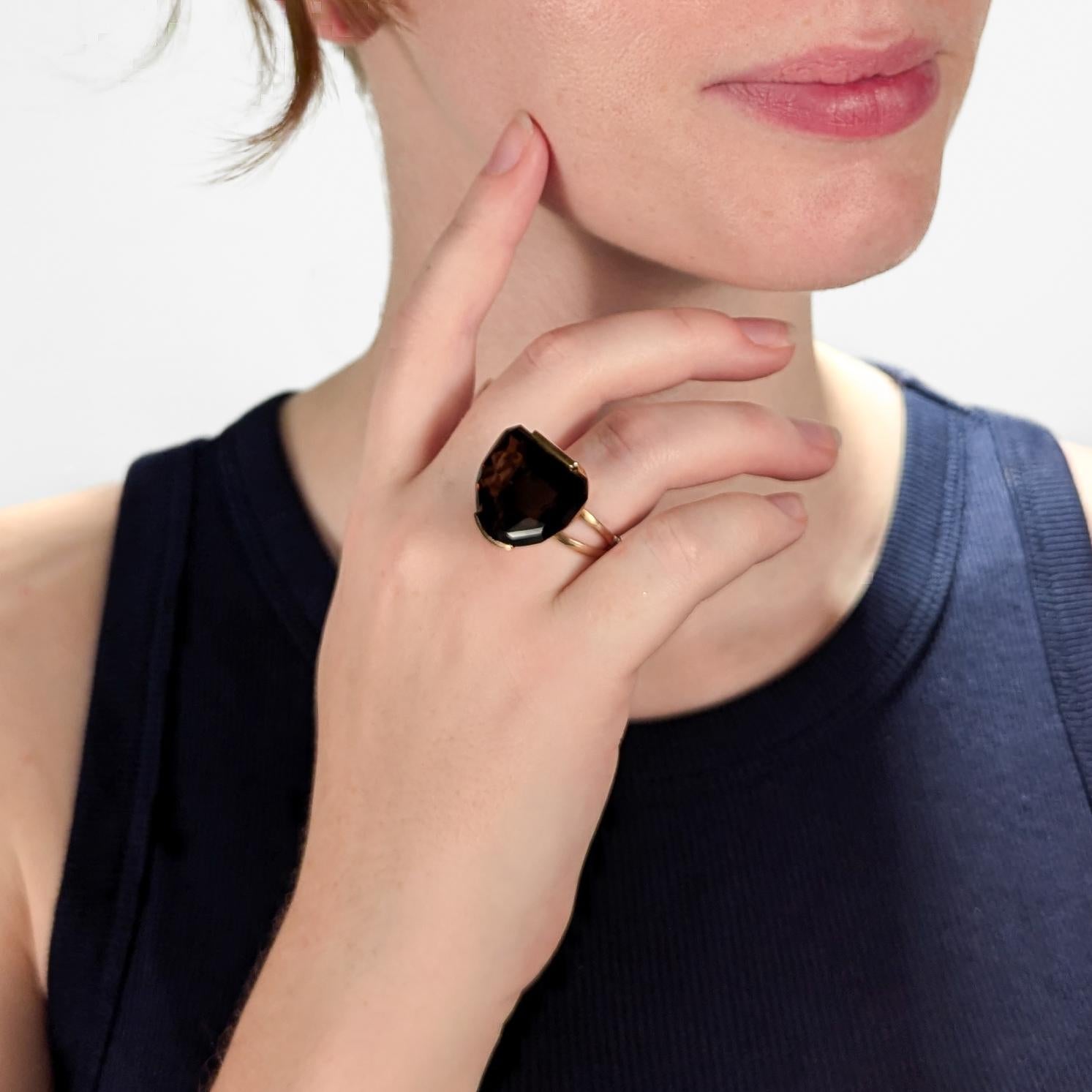 A big Modernist 14K yellow gold cocktail ring.

With a half-moon smoky topaz gemstone tension set in semi-circular open basket. 
It has a split shank that repeats the 'open' design of the basket.

Stamped 14K to the shank for gold fineness.

A great