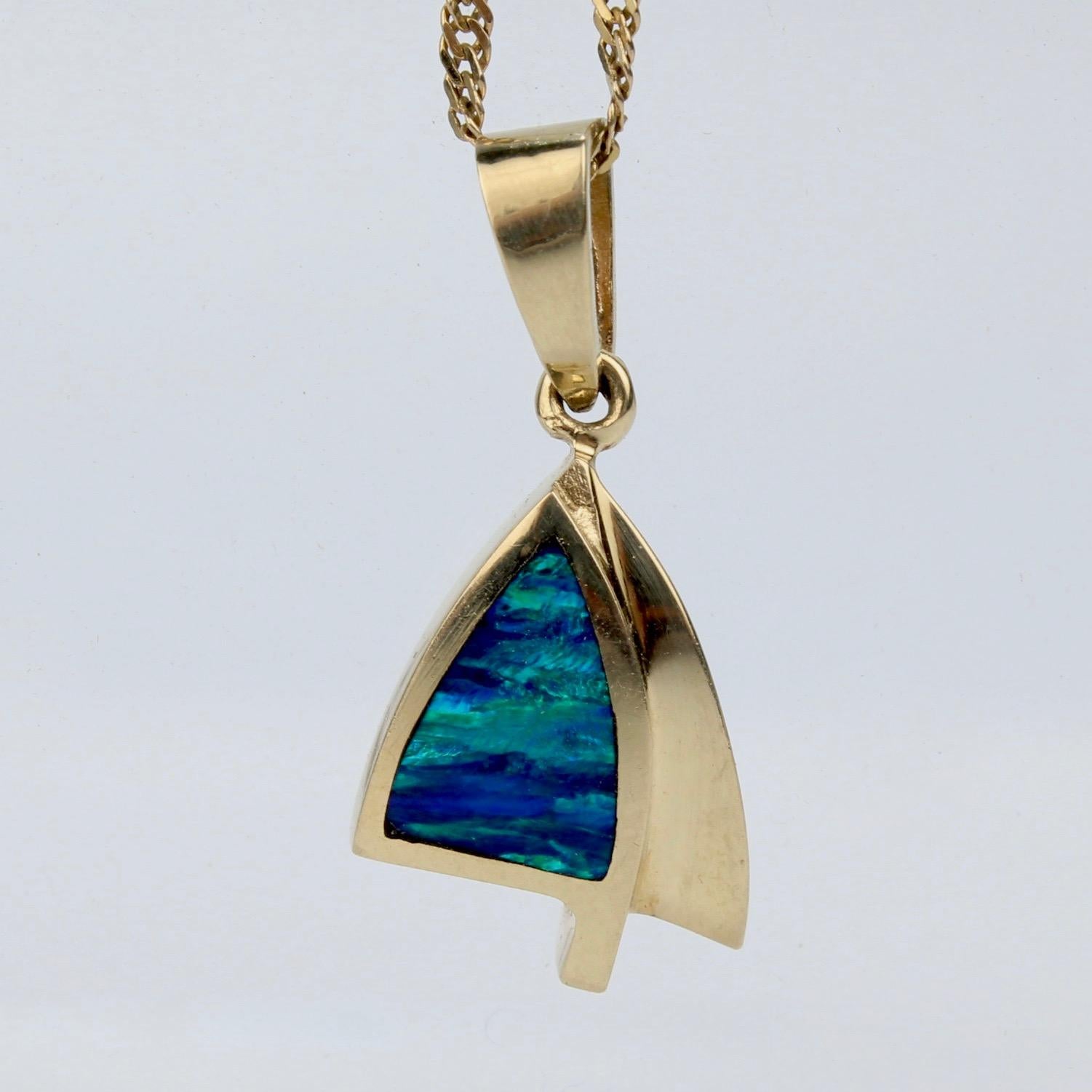 A fun modernist pendant necklace reminiscent of a sailboat's sail.

In 14k gold and set with an opal triplet at its center that reminds one of the sea.

Together with an associated twist chain necklace.

A fun, simple modernist necklace with a