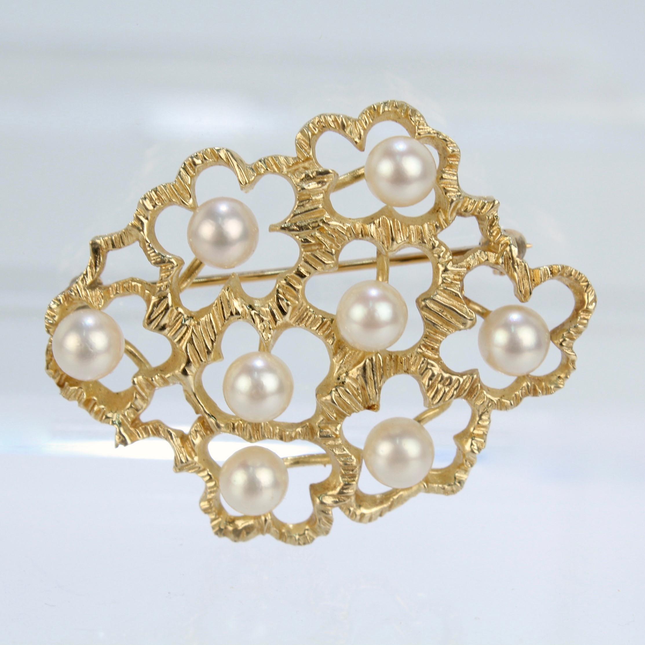 Eine wunderschöne Brosche aus 14k Gelbgold, besetzt mit 8 runden, weißen Perlen.

Die Brosche hat ein modernistisches Design, das an einen Strauß stilisierter mehrblättriger Blumen mit je einer Perle in der Mitte erinnert.

Auf der Rückseite 14k für