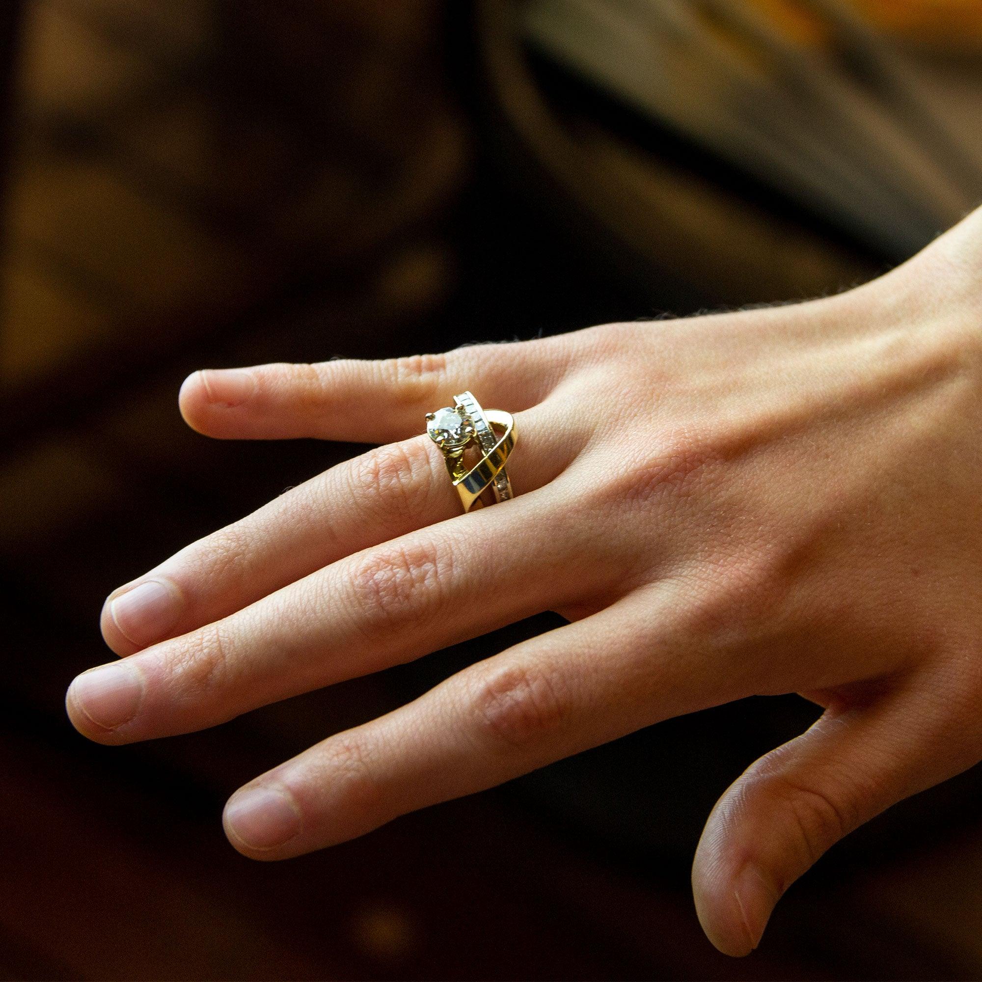 Ein ungewöhnlicher zweifarbiger Ring aus 14 Karat Gold, besetzt mit Diamanten in einem modernen asymmetrischen Stil. Der Ring ist mit einem 1,05 Karat schweren Diamanten im halbmodernen Brillantschliff mit der Farbe J/K und der Reinheit VS1 in einer