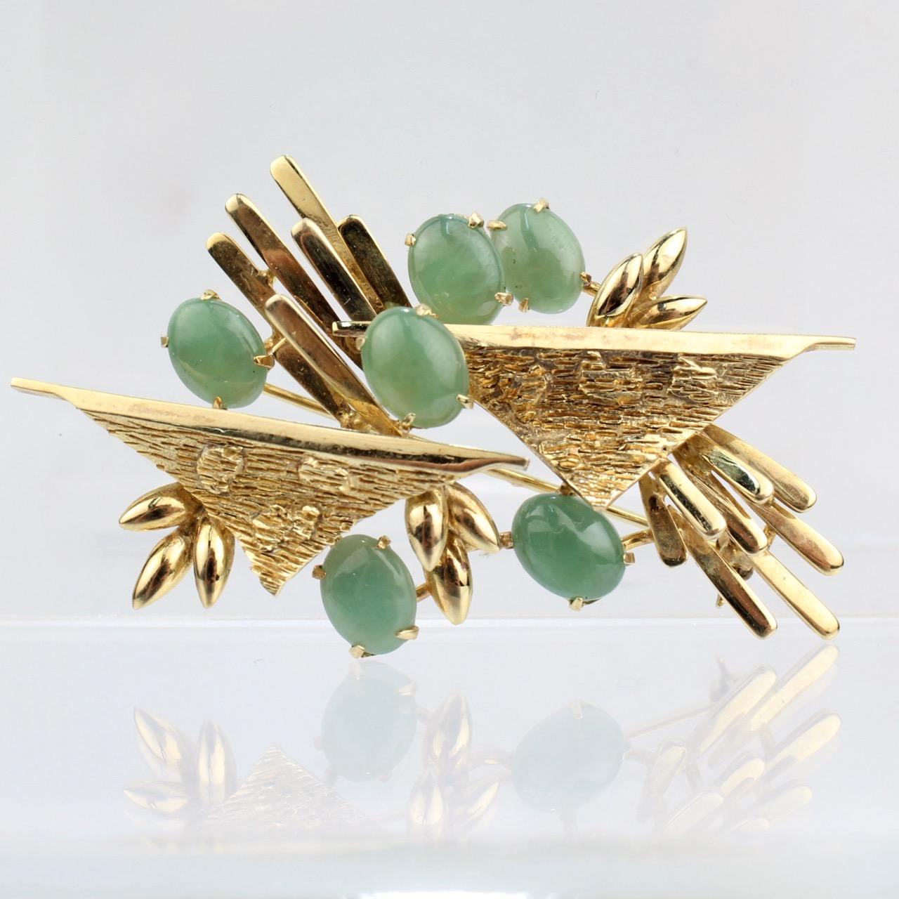 A wonderful 18k gold and nephrite jade brooch. 

With textured gold elements offset with 6 jade cabochons. 

Simple & visually exciting modernist design!

Marked 18K to the reverse.

Length: ca. 55 mm

Items purchased from this dealer must delight