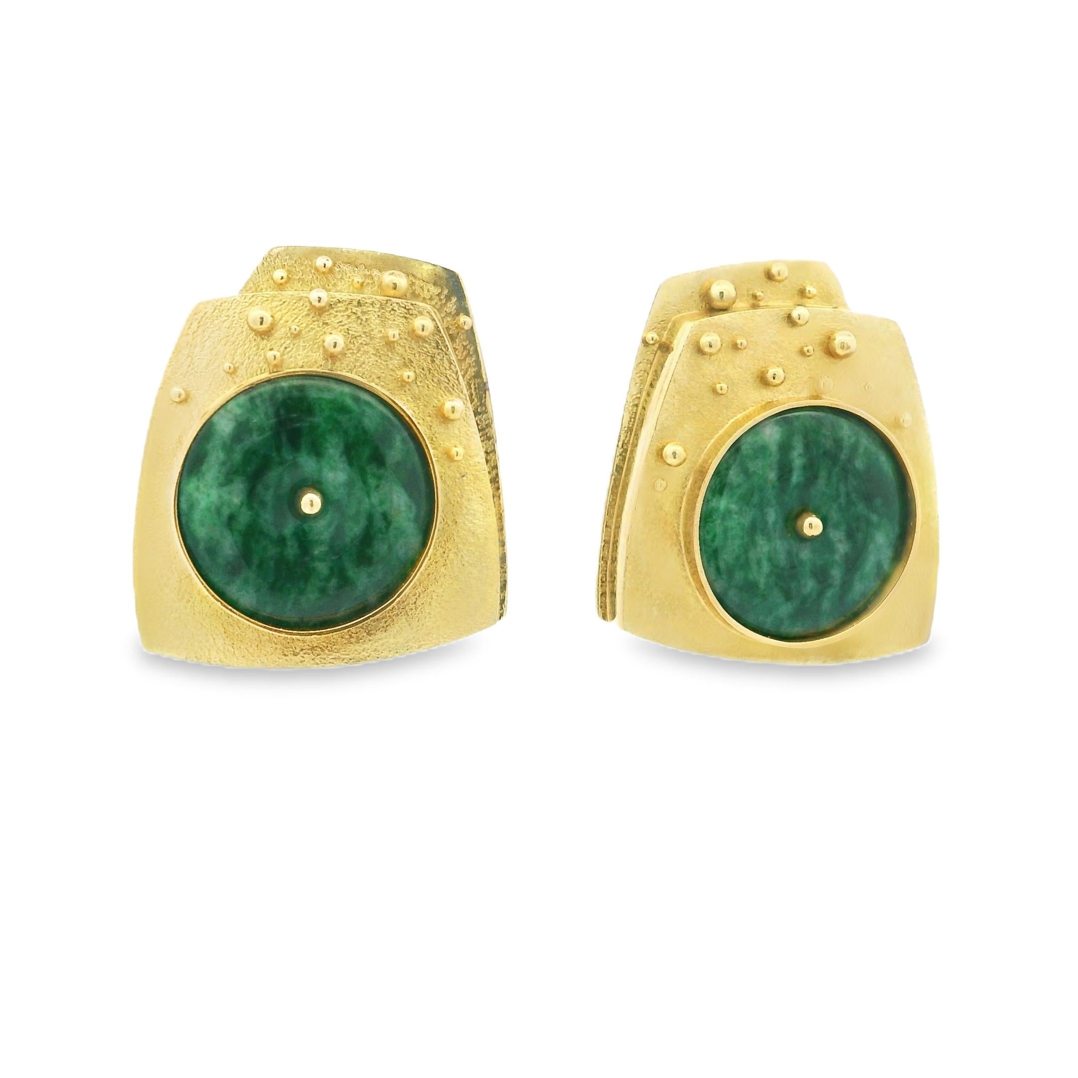 Un originale paio di orecchini vintage modernisti realizzati in ricco oro giallo 18 carati, con dischi rotondi di giada naturale al centro di un design architettonico e asimmetrico. Ogni orecchino presenta un cabochon di giada verde splendidamente