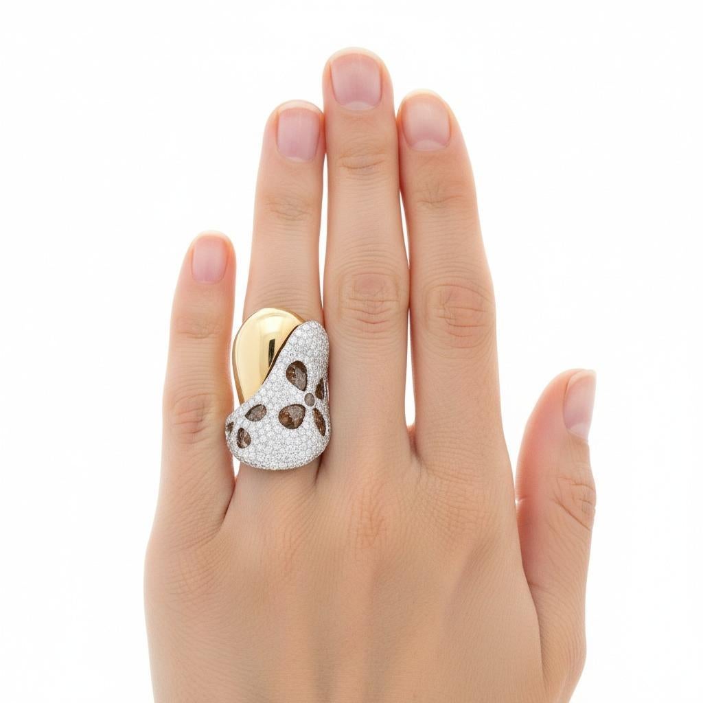 Questo splendido anello largo da cocktail mostra un'eccezionale maestria contemporanea, sapientemente realizzato in lucente oro giallo e bianco 18 carati e caratterizzato da uno splendido pavé di diamanti rotondi con taglio a brillante per un totale