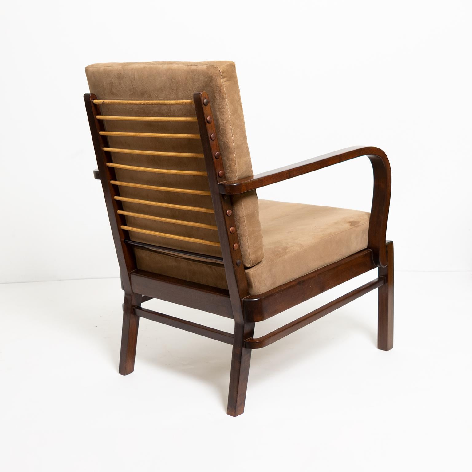A modernist lounge chair designed by Wilhelm and Willy Knoll for Knoll Antimott, Germany 1920s. The light weight stained wood frame exemplified early 20th century modern furniture design. The back cushion is supported with “exposed” springs wrapped