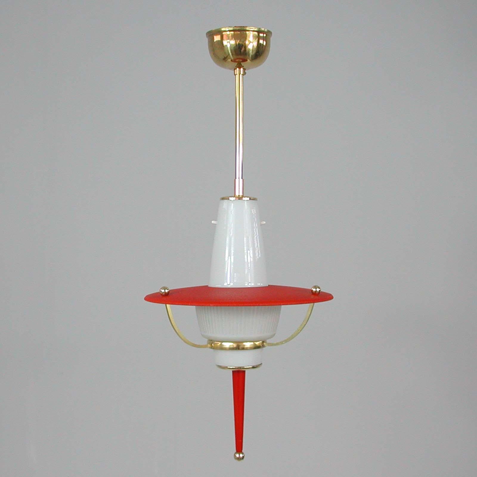 This unusual midcentury pendant was designed and manufactured in Italy in the 1950s. It features a red crinkle lacquered shade, a white milk glass striped lamp shade and brass hardware. The light requires one E14 bulb.

The light has been rewired