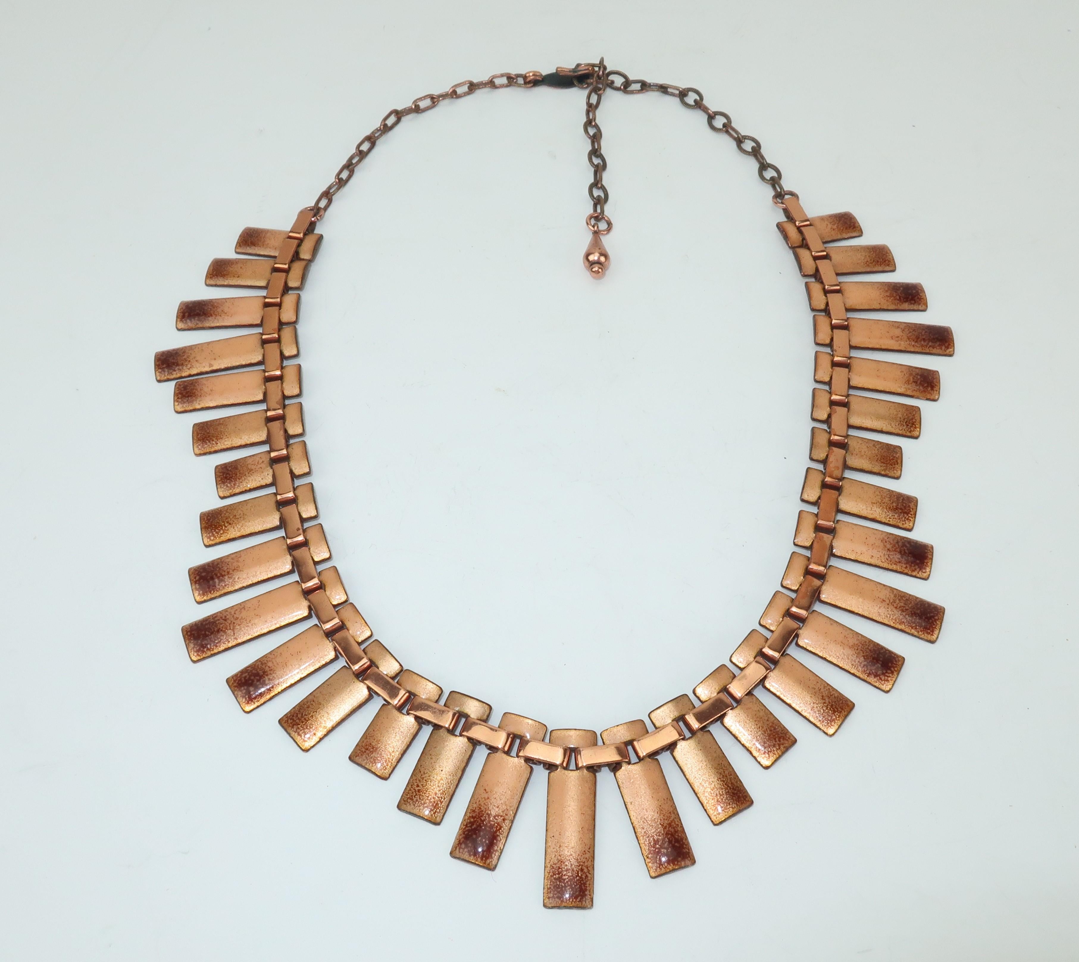 This 1950’s copper enamel necklace by Matisse has a modernist silhouette with an exotic vibe perfect for adding a little vintage to your look.  The golden toned enameled pieces are fanned out at different lengths by flat copper links all connected
