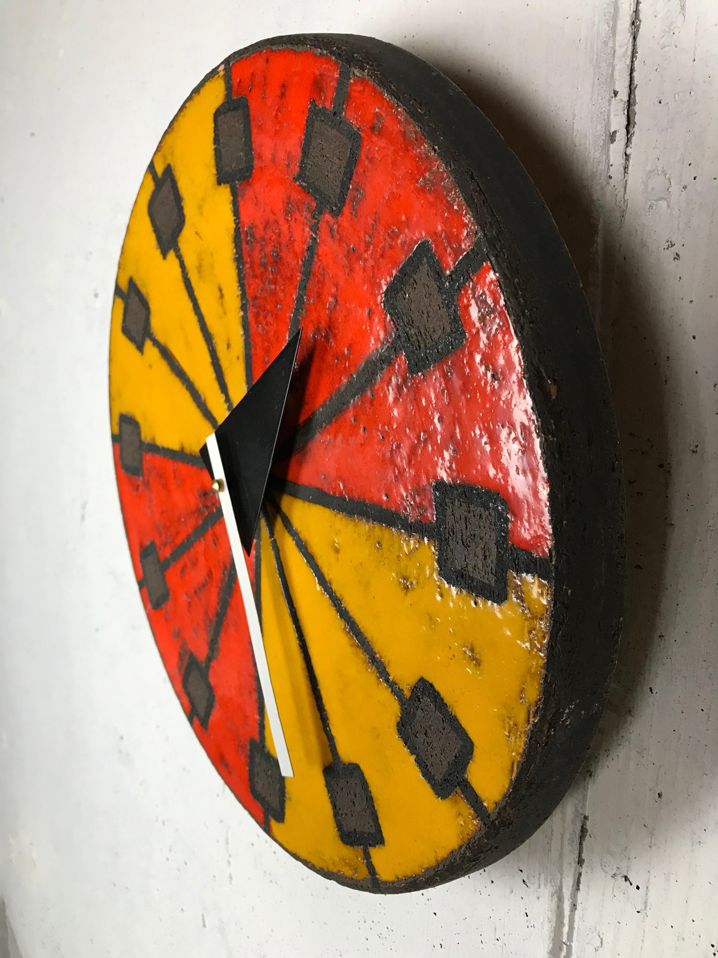 Eye-catching modernist Italian ceramic wall clock by Bitossi (Italian potter) manufactured by Howard Miller using hands designed by Goerge Nelson (American designer). This desirable glaze has brilliant red and orange colors and a sgraffito technique