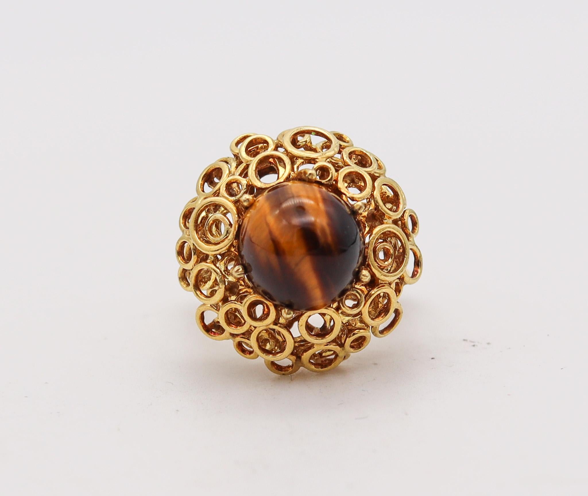 Modernist sculptural ring with tiger's eye.

Beautiful and very unusual cocktail ring, created in Europe, most probably in Italy with modernist patterns, back in the 1970. It was individually assembled with multiples circular elements made up from