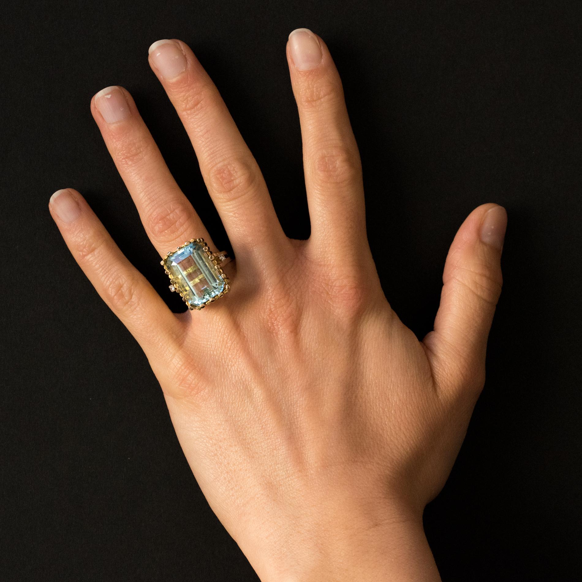 Ring in 14 Karats yellow gold, shell hallmark.
Splendid modernist ring, it is set with an emerald- cut aquamarine shouldered on both sides on the departure of the ring by a brilliant- cut diamond.
Weight of aquamarine: about 14.2 carats, total