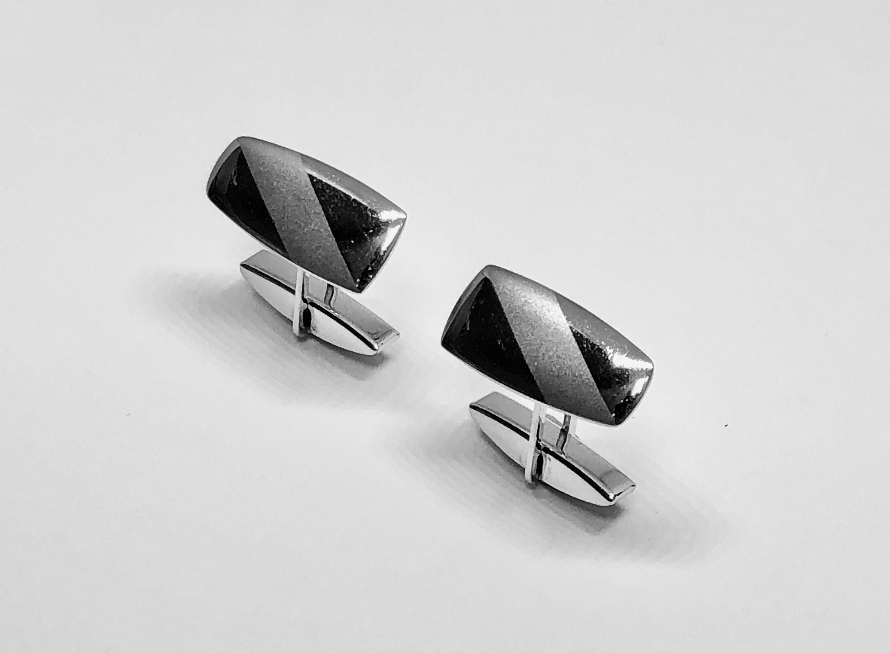 Modernist style white 9k gold cuff links. The gold is polished with a brushed gold strip running diagonally through the design. Gold marks. Made in 2004. The cufflinks feature a whale-back fastener.