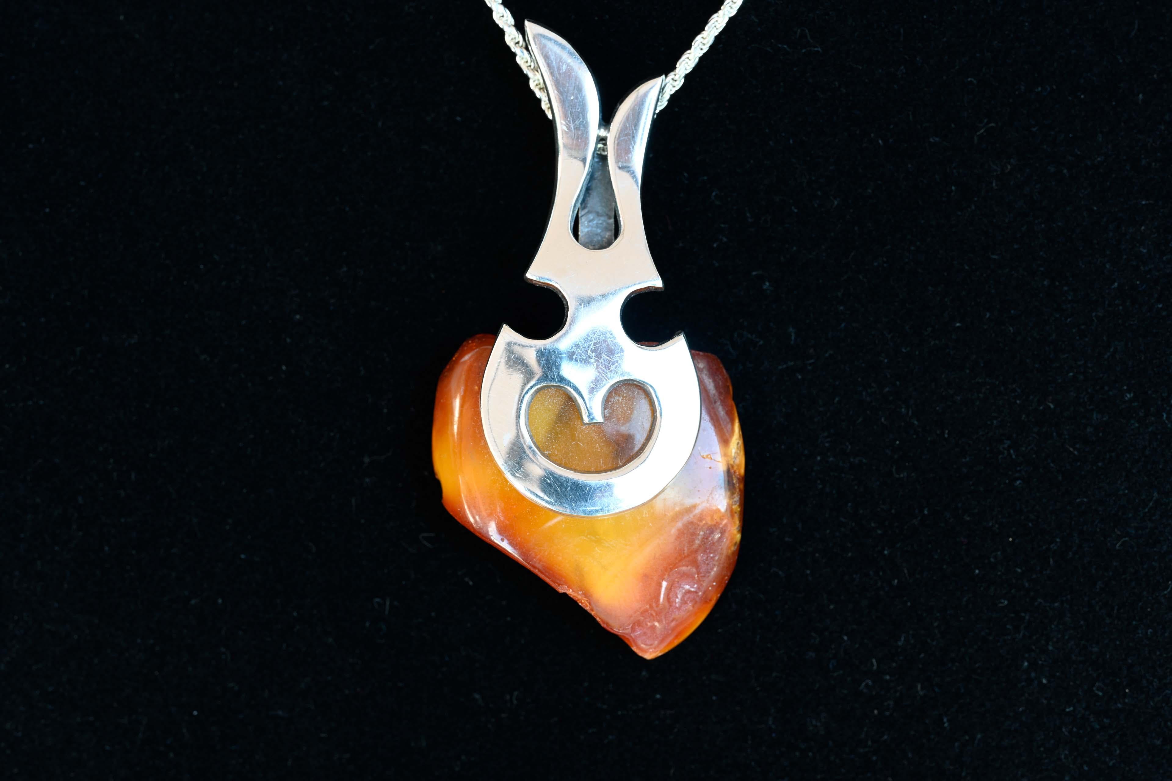 Modern 925 silver and baltic amber chain pendant. The chain is stamped 925 Italy. The chain measures 16 inches and the pendant measures 2 3/4 inches long. In good condition. 