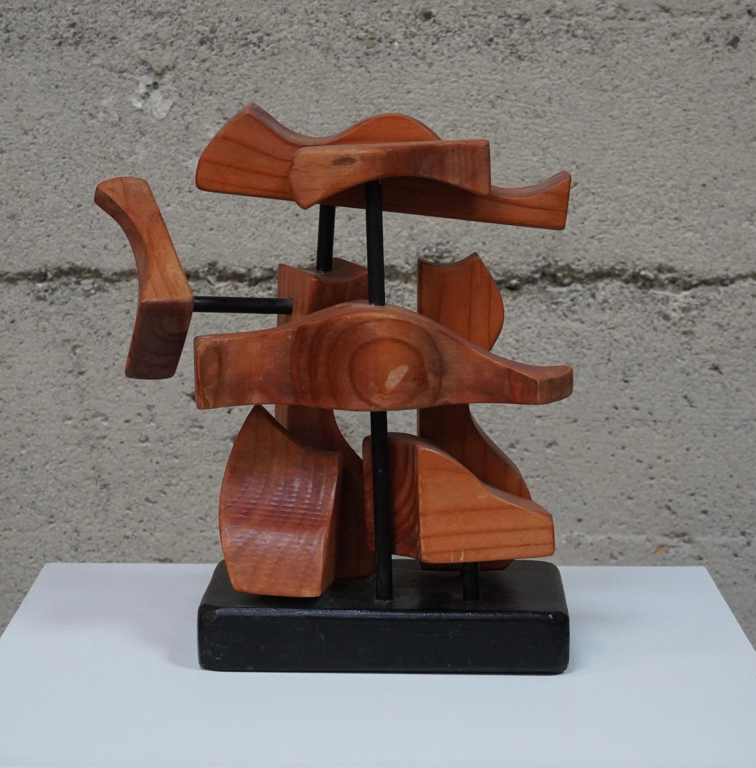 Freeform abstract wooden sculpture, hand-carved forms that are connected via dowels and mounted on a black wooden base. Each element of the sculpture relate to one another to create a visual flow.