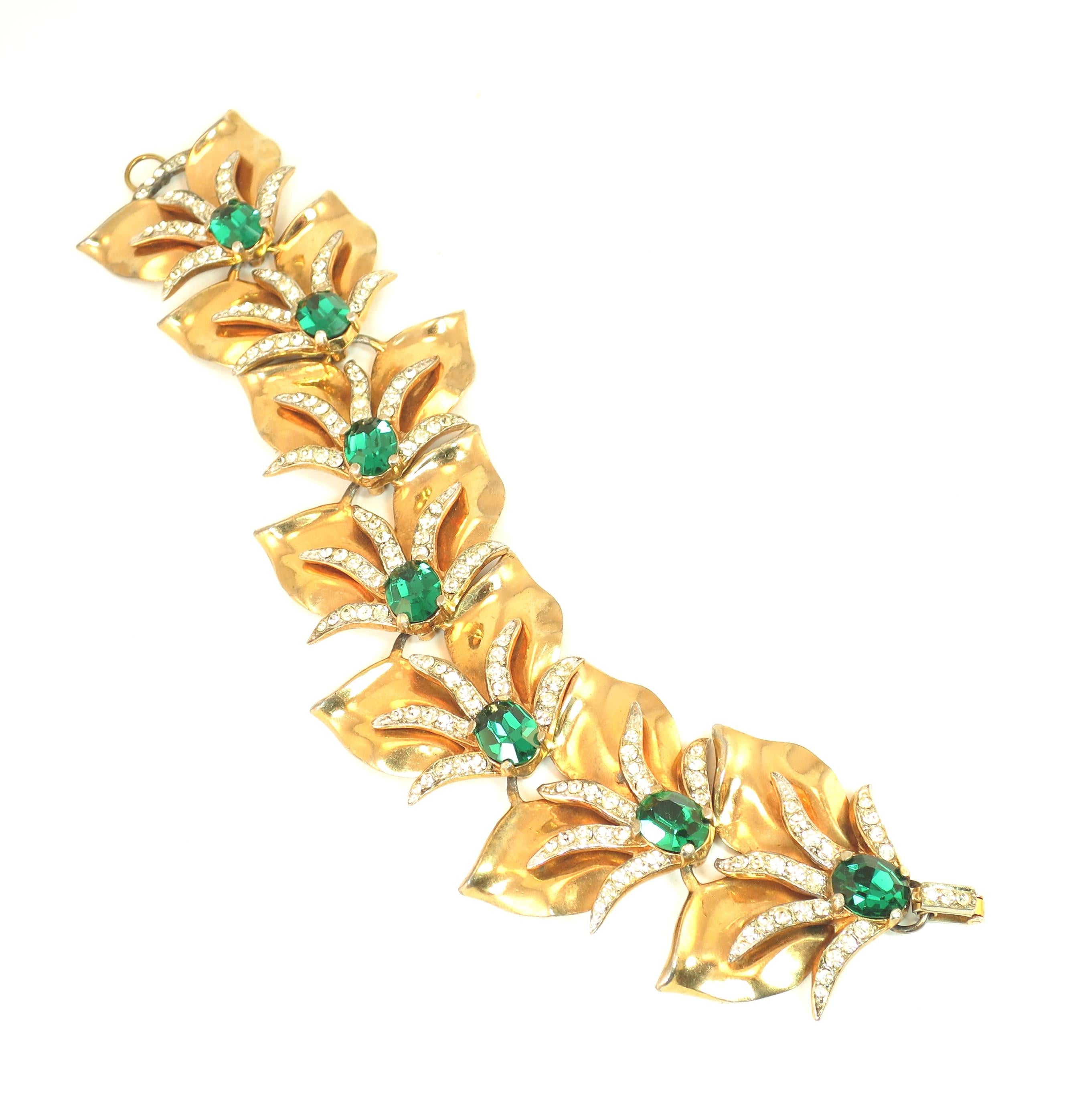 Offered here is a massive Modernist abstract gold-plated emerald crystal bracelet from the 1940s. The construction consists of seven solid platforms connected by built-in links and hooks; each section expresses a stylized double-leaf design
