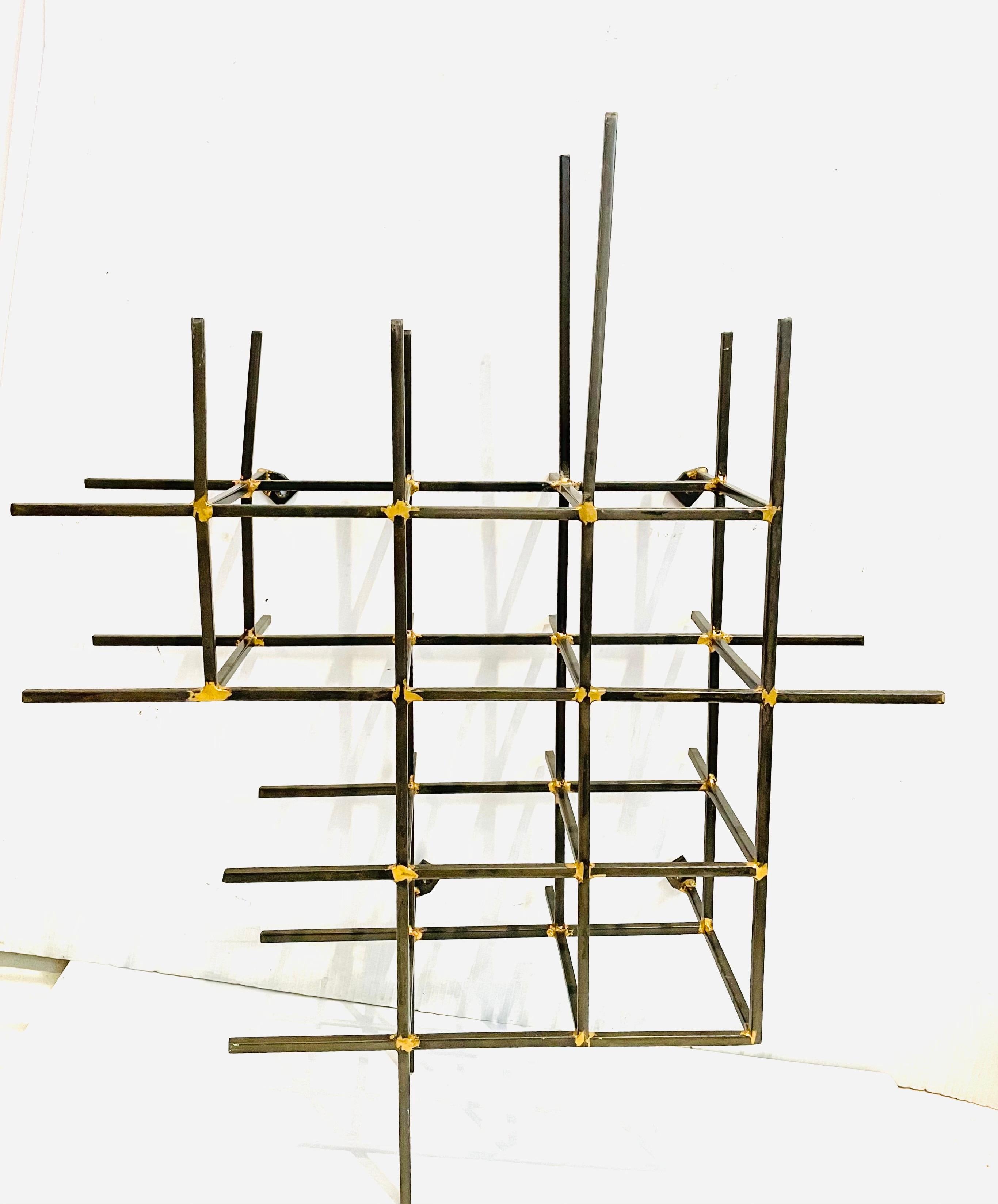 Really cool and unique abstract solid steel with brass welded rods wall sculpture can be hung in many positions. it can be used as a wine rack.