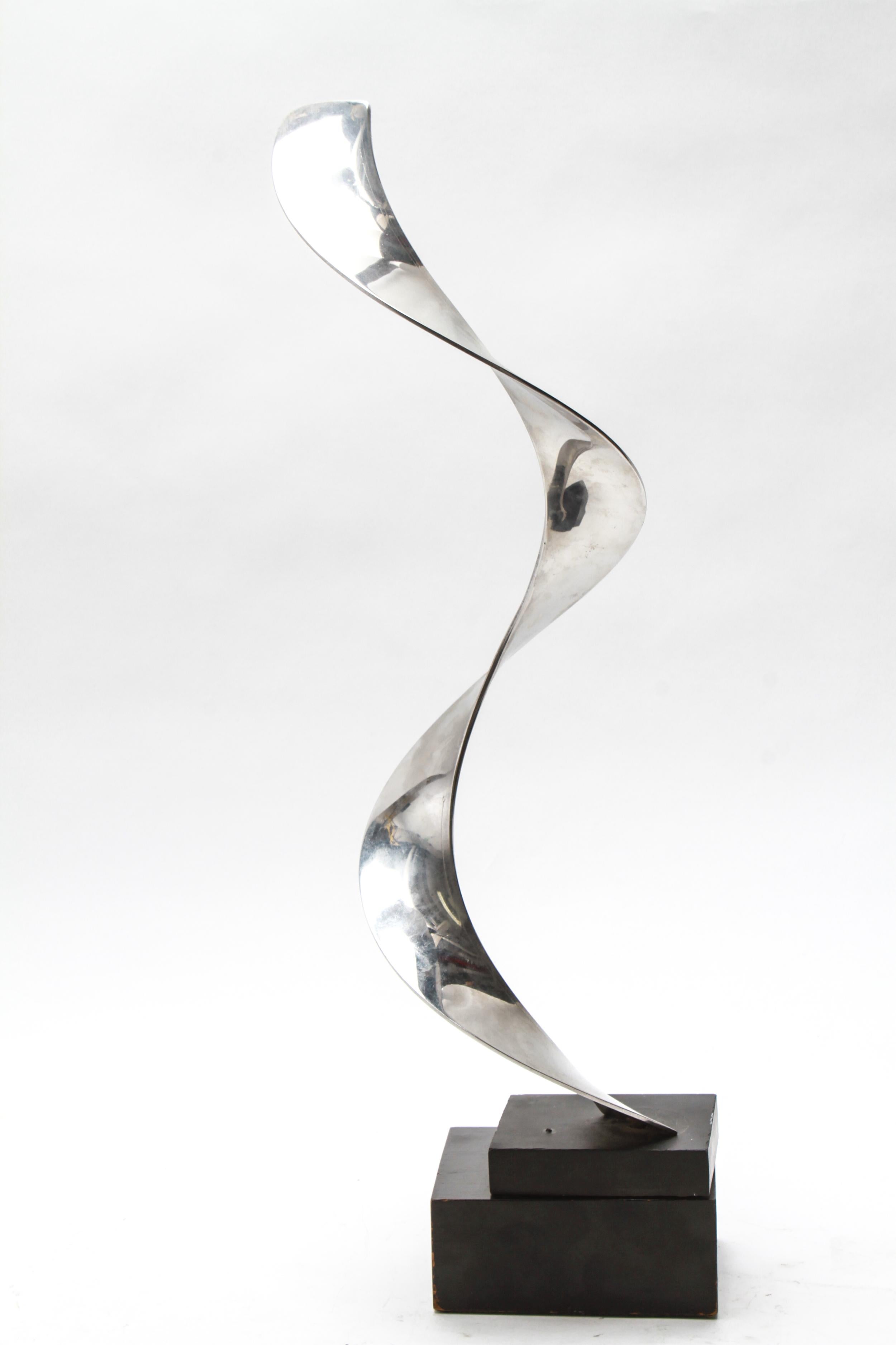 Modernist abstract sculpture of a twisting ribbon on an oblong black base. The piece is made of chromed metal and is in great vintage condition with age-appropriate wear.