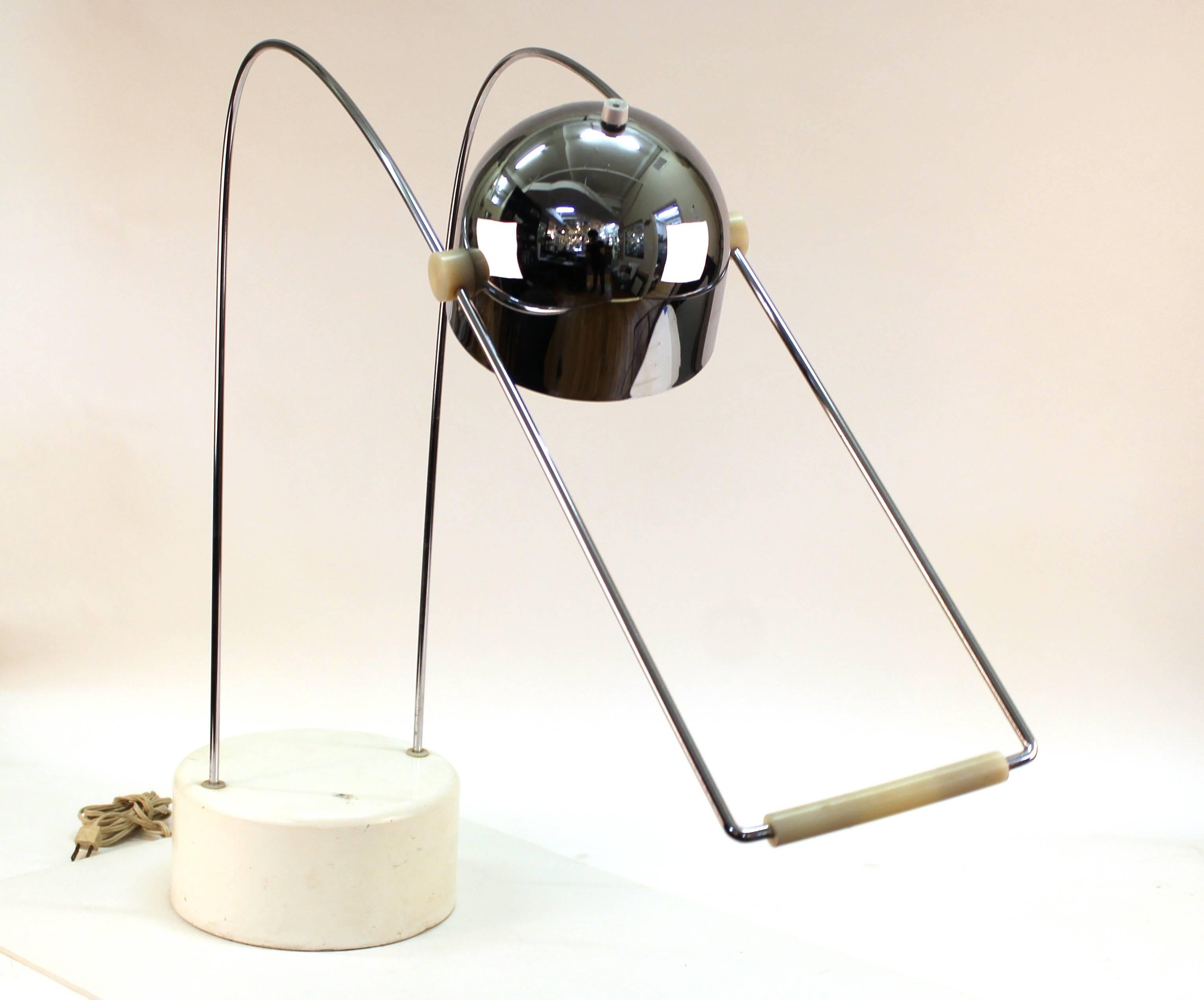 A modernist desk lamp with an adjustable chrome head. Some scraps and chips to the lamp's base, but overall the piece is in great vintage condition.