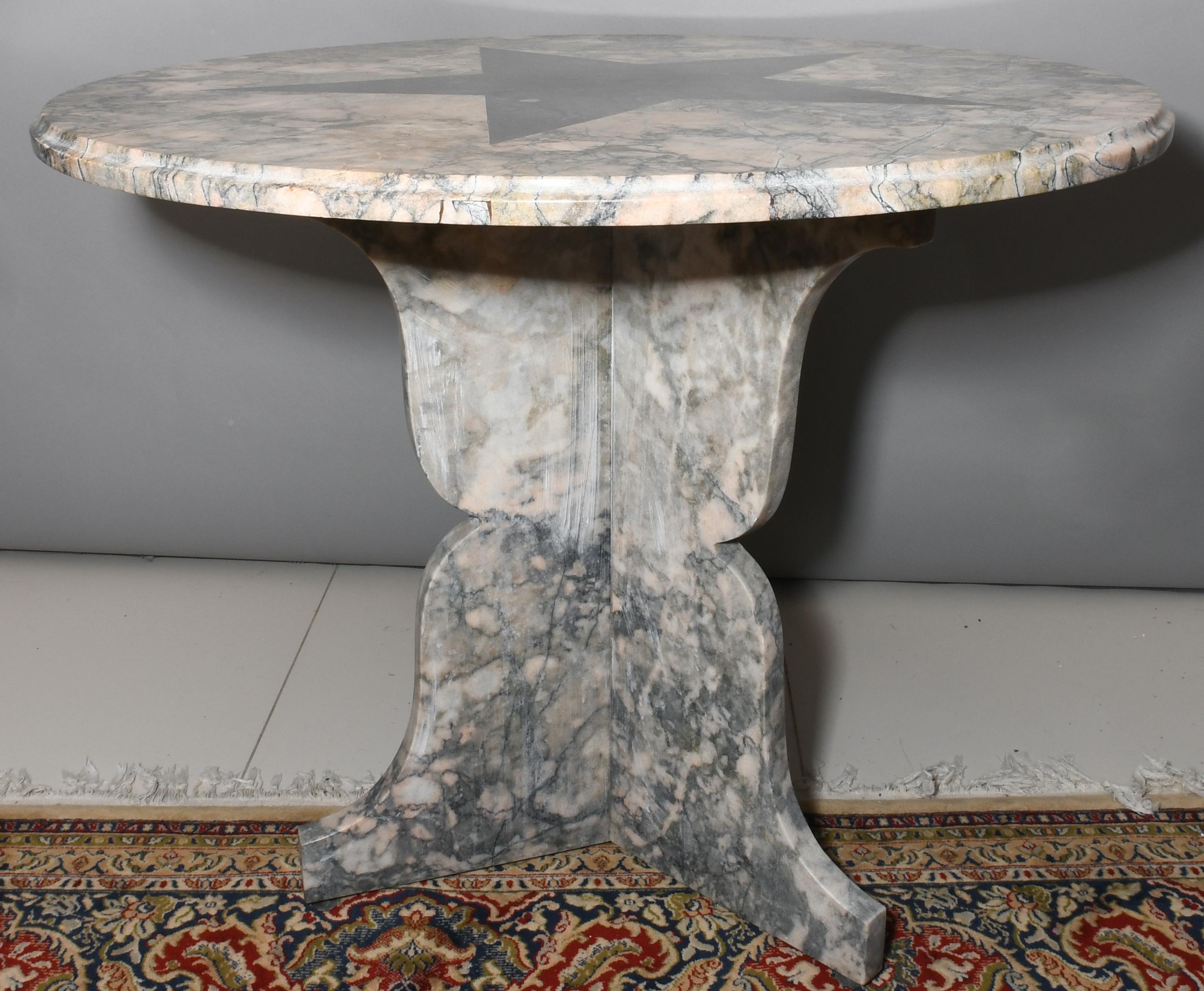 A Calacatta pink marble center table made in the 1970s with a black large five pointed star design at the top of it. The star- the North star - symbolizes a beacon of inspiration, hope, and direction. The tripod base of the table is also made of