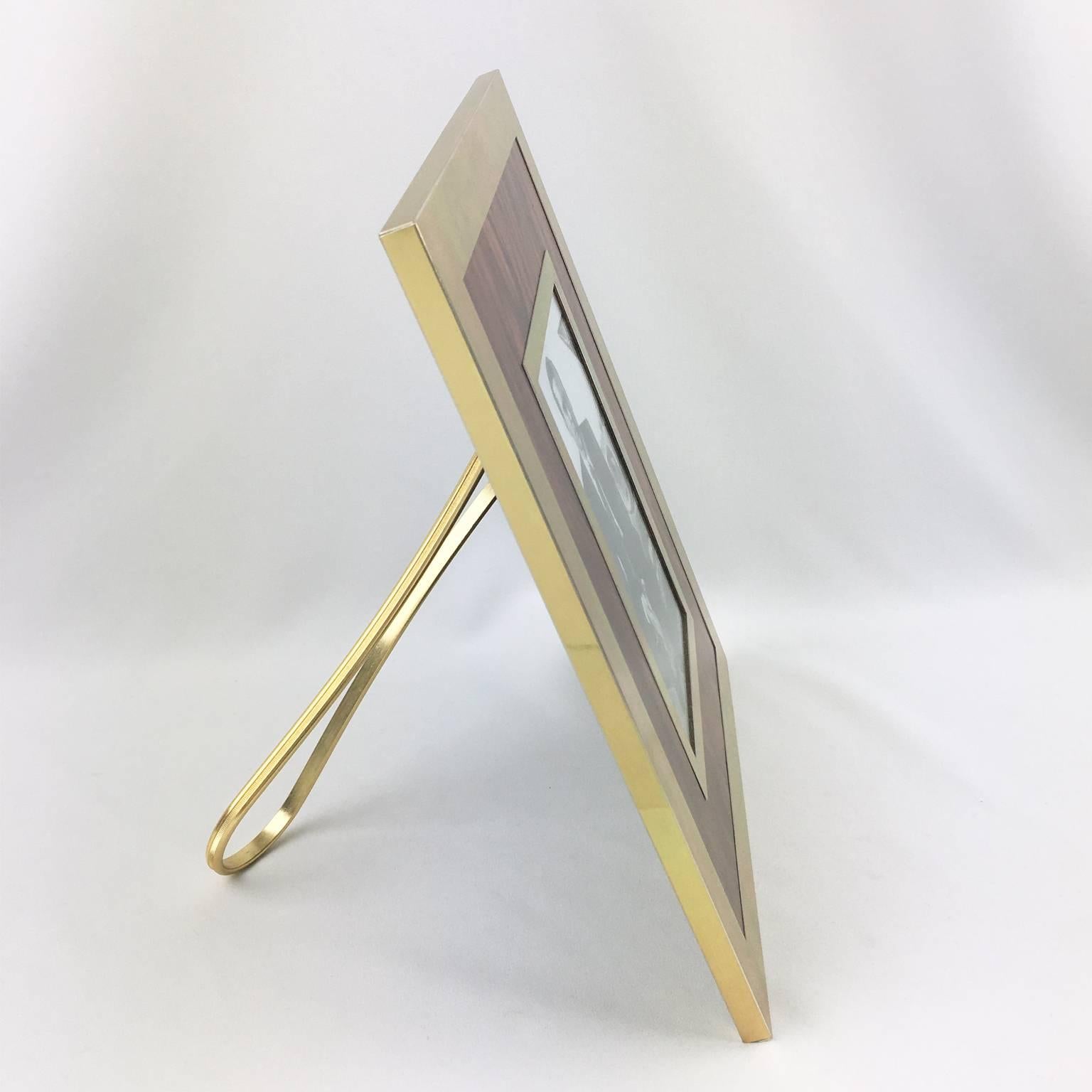 Lovely vintage Mid-Century Modern picture photo frame, manufactured by Italian designer MB. Gilded aluminum and formica imitating flamed walnut wood. Metal easel at the back. Marked on easel: 'Made in Italy - MB brand logo'.
Please check our