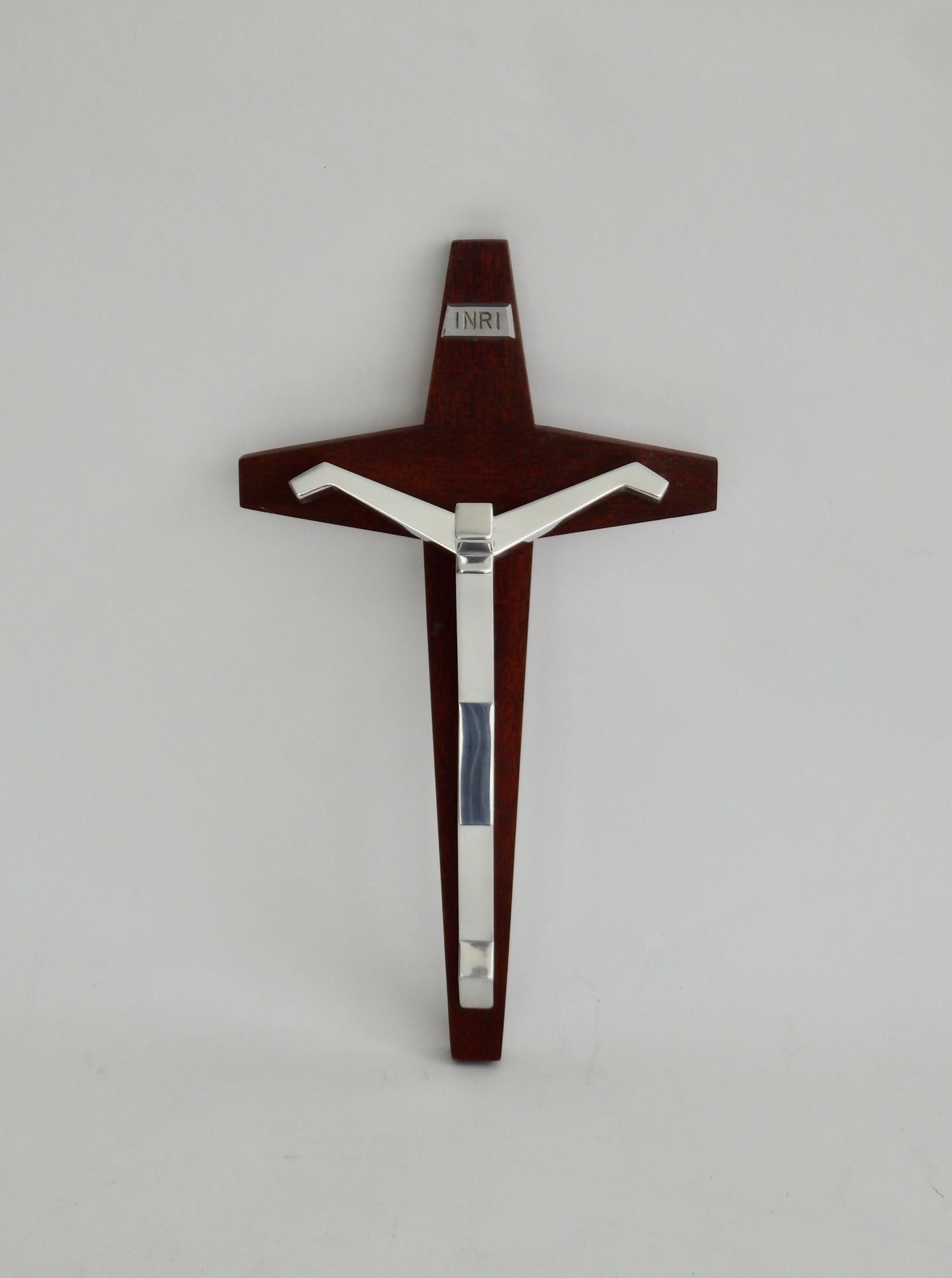 Stylized figure of Christ in polished aluminum on mahogany cross.