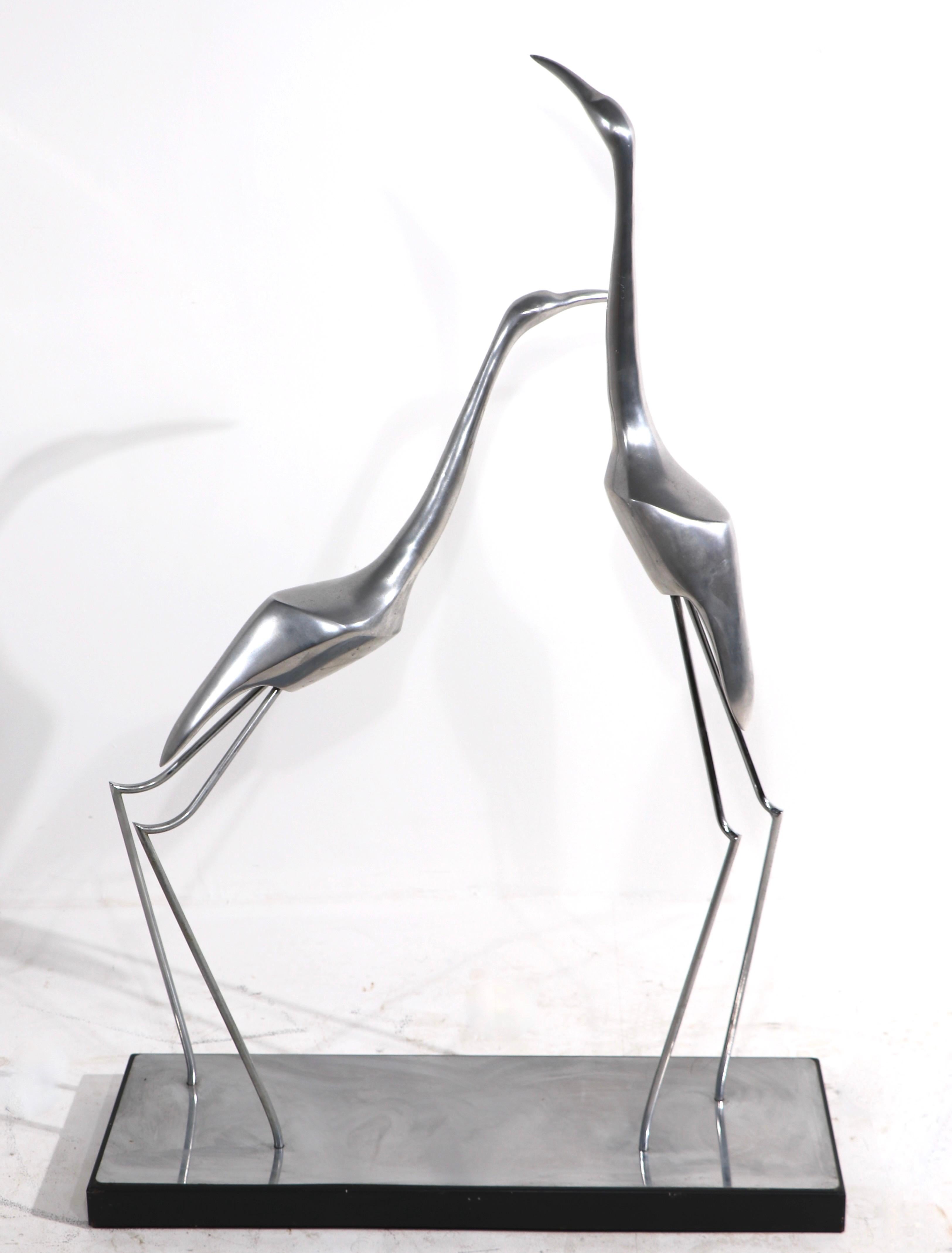 Impressive sculpture depicting two stylized Herons of cast aluminum on a rectangular base ( 30 in. W X 10 in. D ). This example is in very good original condition showing only light cosmetic wear normal and consistent with age. Made by Curtis Jere