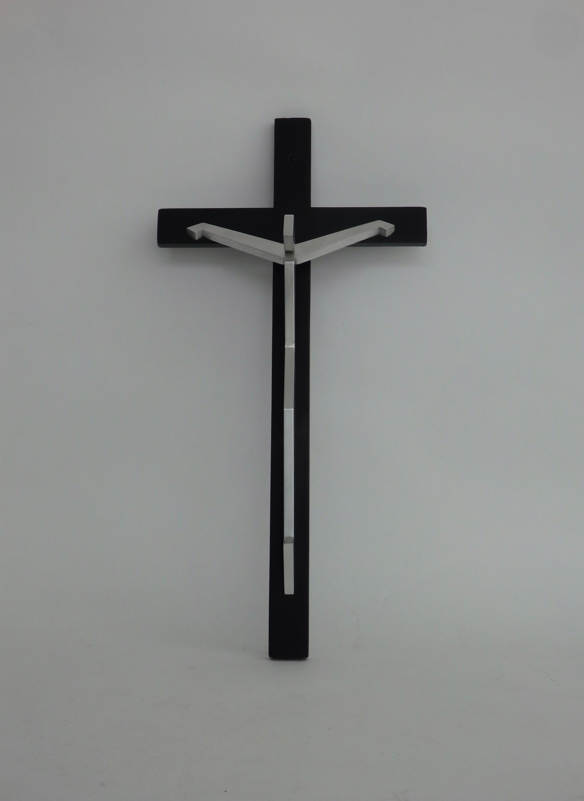Stylized figure of Christ on black lacquered cross.